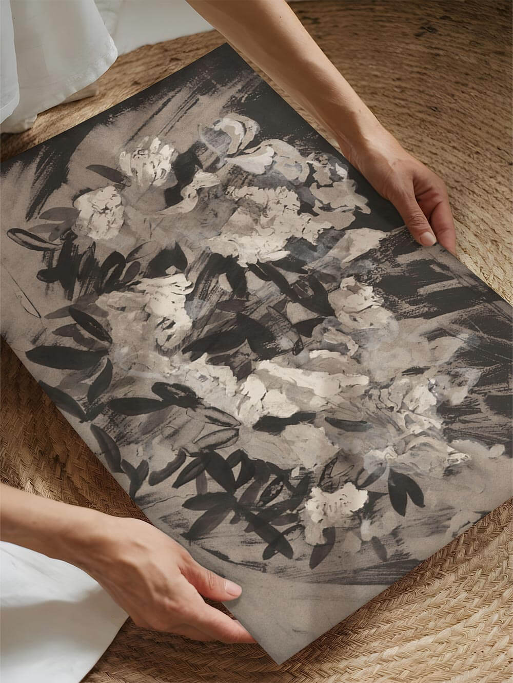 Floraler Kunstdruck in Nahaufnahme, von zwei Händen gehalten. Die malerische Textur und die zarten Kontraste der Blätter sind gut zu erkennen.