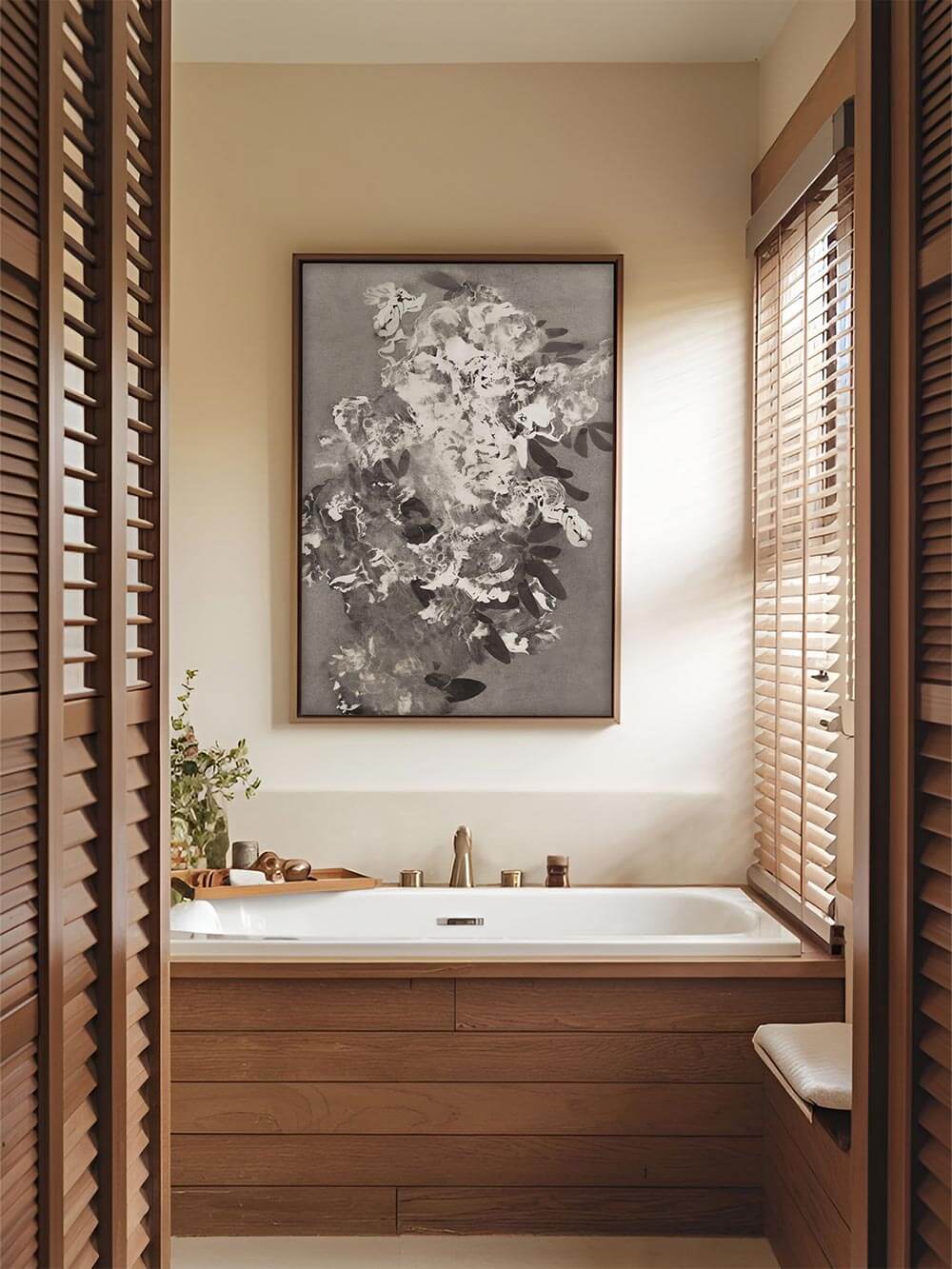 Ein großformatiger Blumen Kunstdruck schmückt die Wand über der Badewanne. Das monochrome Motiv ergänzt die harmonisch gestaltete Spa-Atmosphäre.