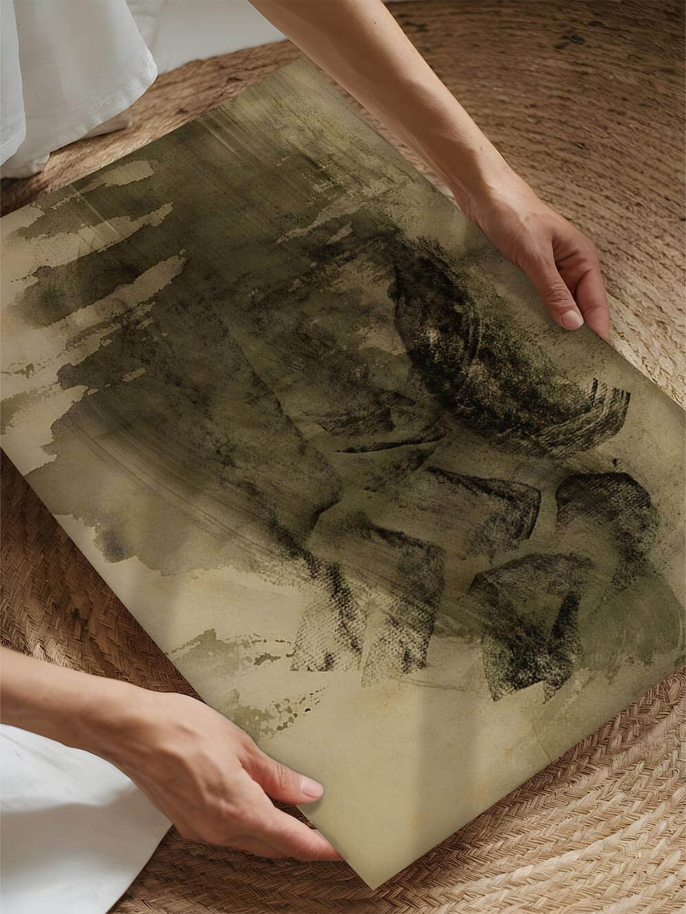 Ein gerahmter Kunstdruck in Wabi-Sabi-Stil wird von zwei Händen gehalten. Die erdige Farbpalette und strukturreiche Oberfläche stehen im Fokus.