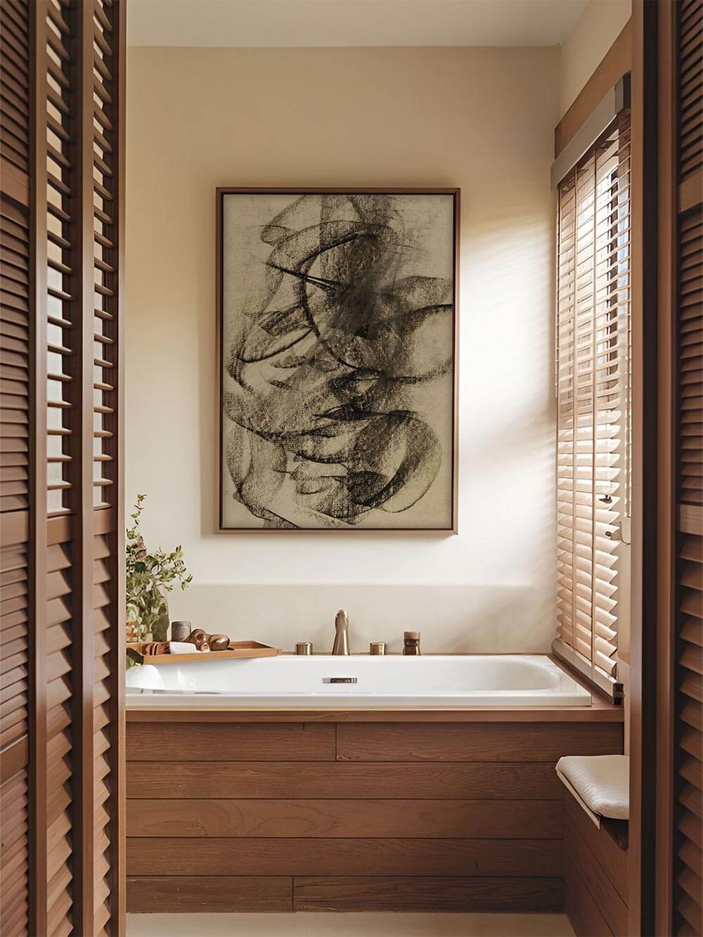 Der abstrakte Kunstdruck in gedeckten Naturtönen hängt über einer weißen Badewanne. Die dynamische Linienführung bringt dezente Bewegung in das minimalistisch gestaltete Badezimmer.