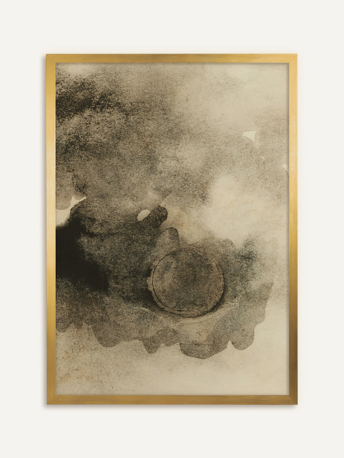 Wandbild, das wolkige Tuscheflächen in Grau und Schwarz auf cremefarbenem Papier zeigt, in deren unterem Teil eine weiche Kreisform liegt. Im goldenen Rahmen bekommt die abstrakte Komposition einen Hauch von Vintage. #Rahmen_Gold