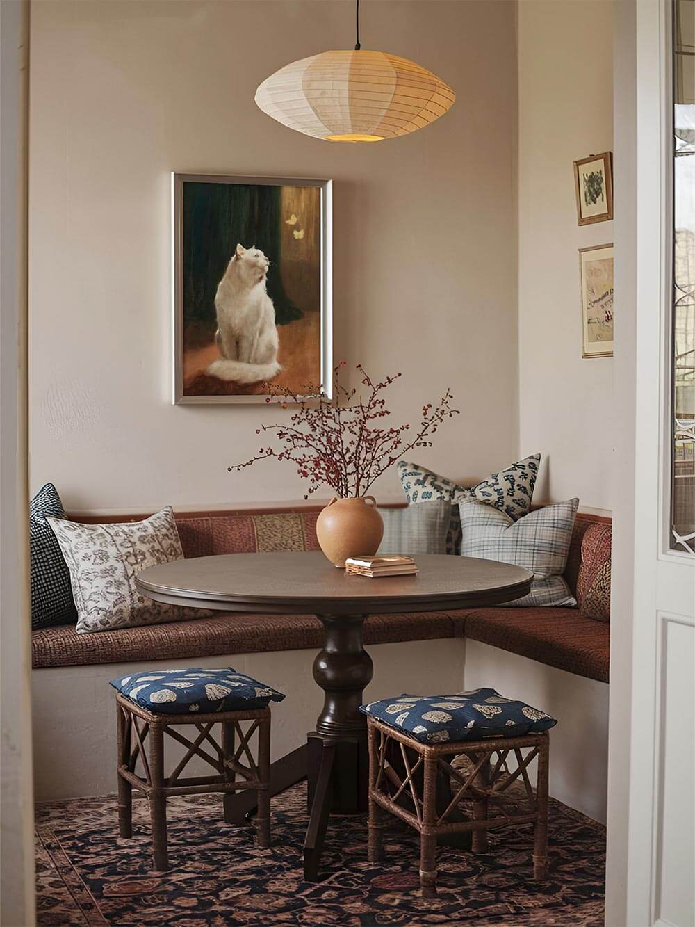 Edler Kunstdruck einer weißen Katze mit zwei Schmetterlingen, in einer gemütlichen Essecke gerahmt. Harmonische Vintage-Farbpalette mit warmem Licht und dunklen Akzenten.