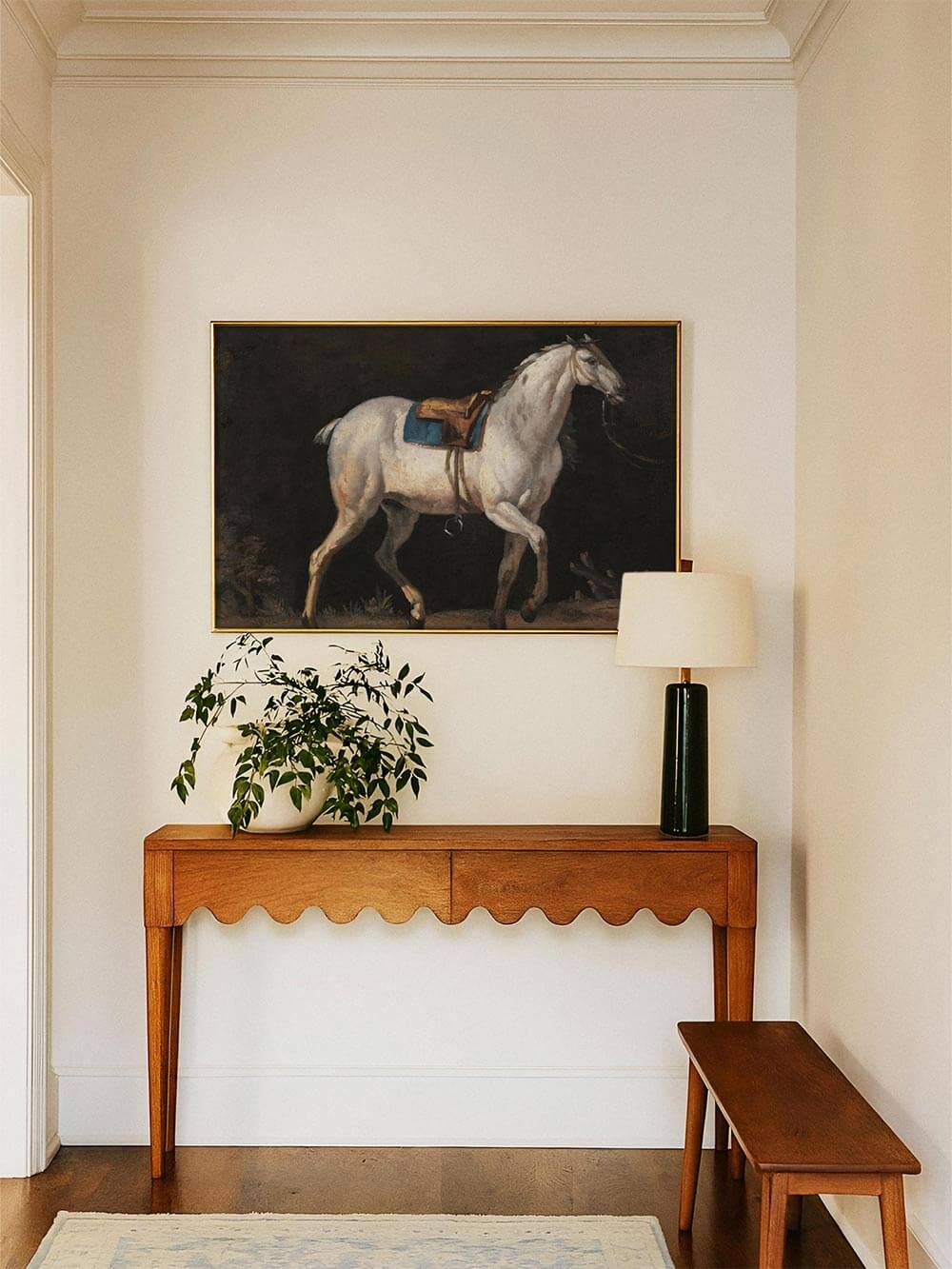 Gerahmter Pferde-Kunstdruck über einer schlichten Konsole in einem hellen Raum arrangiert, kombiniert mit natürlichen Materialien und zurückhaltender Dekoration. Das klassische Wandbild setzt einen ruhigen, eleganten Akzent im Wohn- oder Eingangsbereich.