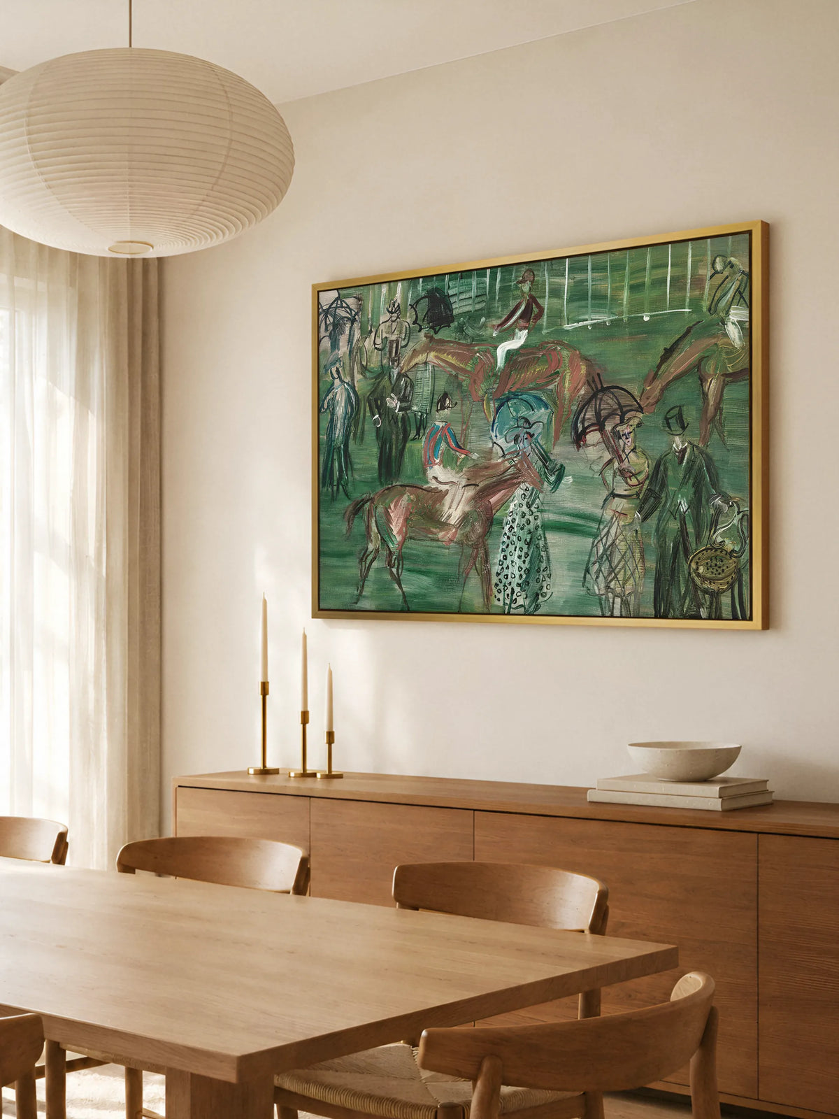 Großes Pferde Leinwandbild im Querformat im goldenen Rahmen über einem Sideboard aus Eichenholz im Esszimmer. Davor stehen ein Holztisch mit Stühlen und drei Messingleuchter mit Kerzen, darüber hängt eine runde Papierlampe.