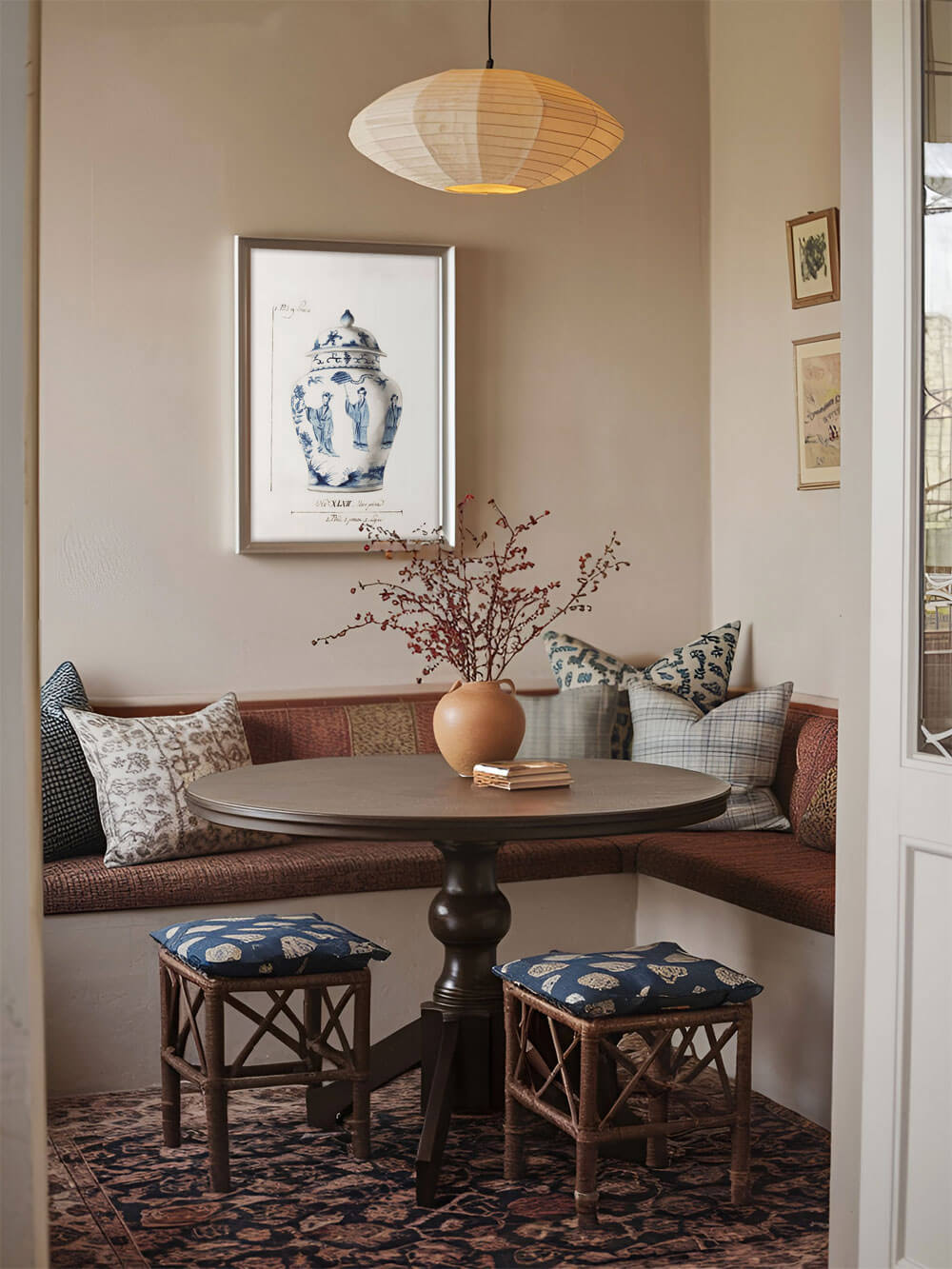 Blauer und weißer Chinoiserie Vasen Kunstdruck in einem Rahmen, der an der Wand einer gemütlichen Essecke mit Holzstuhl und Tisch hängt, dekoriert mit einem blumigen Arrangement.