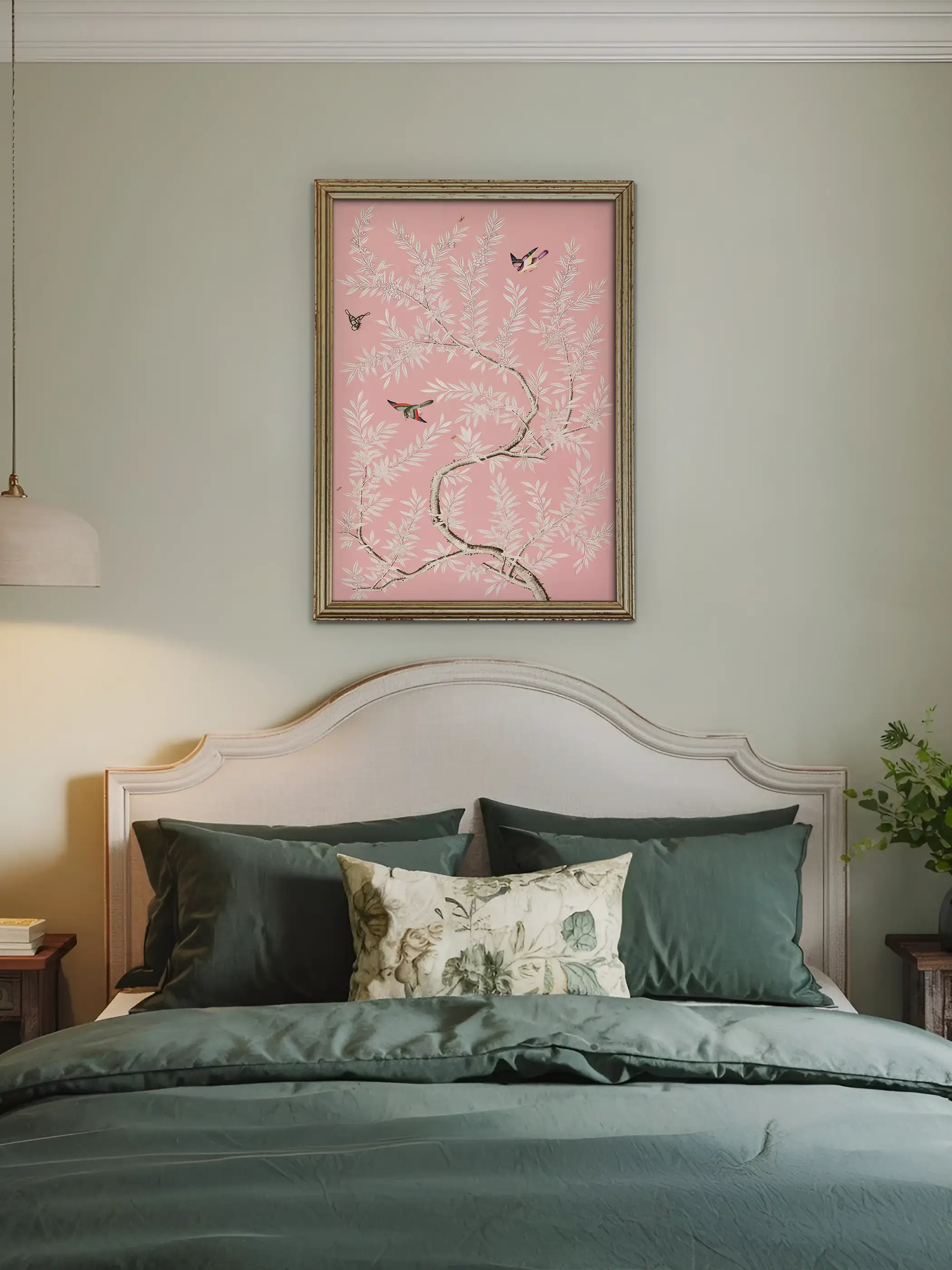 Ein gerahmtes Chinoiserie Poster mit weißen Zweigen und fliegenden Vögeln hängt über dem Bett im Schlafzimmer. Die rosa Farbgebung und die filigranen Motive schaffen eine ruhige und romantische Wandgestaltung.