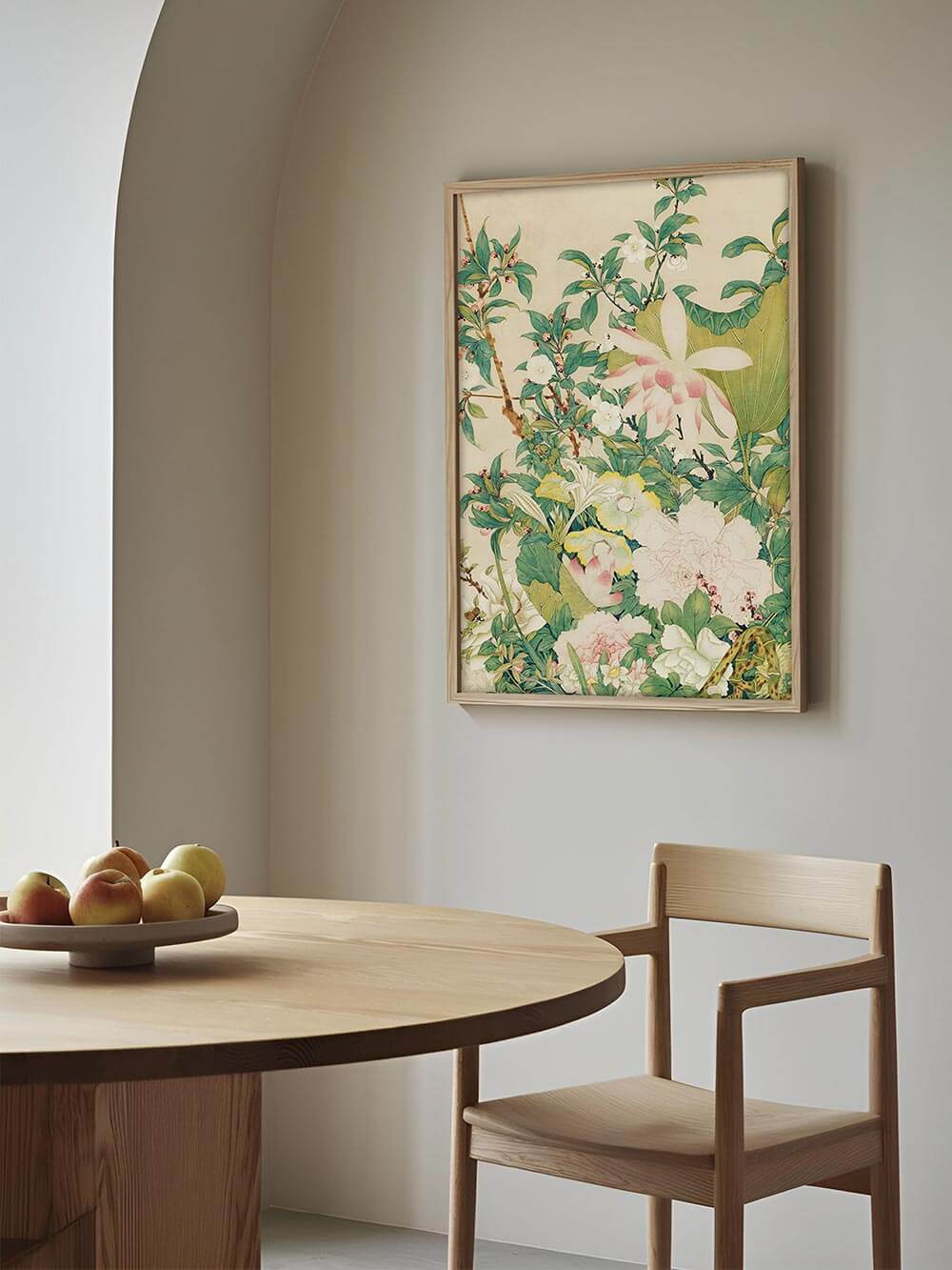 Der florale Kunstdruck im Chinoiserie-Stil hängt gerahmt an einer hellen Wand über einem runden Holztisch. Das Wandbild wirkt frisch und elegant im modernen Esszimmer.