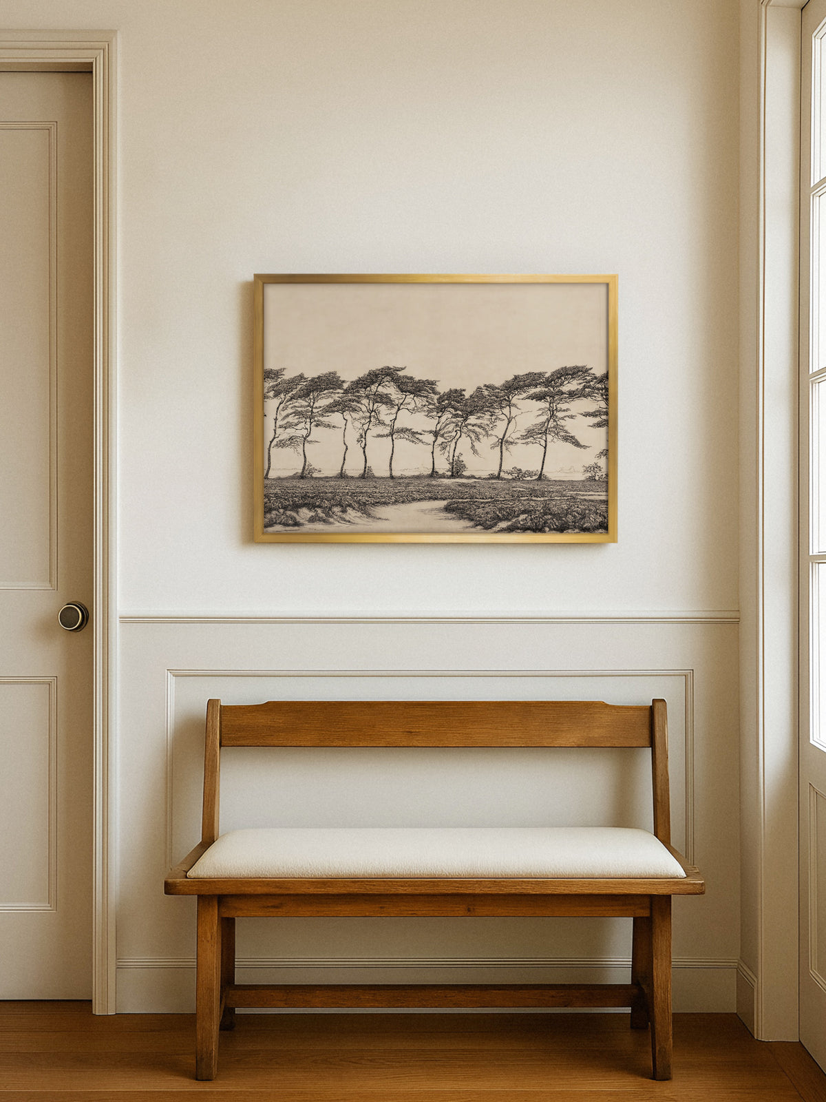 Kunstdruck mit windgebeugten Kiefern im goldenen Rahmen über einer Holzbank mit heller Sitzfläche in einem Flur mit Wandvertäfelung, daneben eine Tür und ein Fenster. Das Vintage Wandbild bringt Ruhe in den Eingangsbereich.