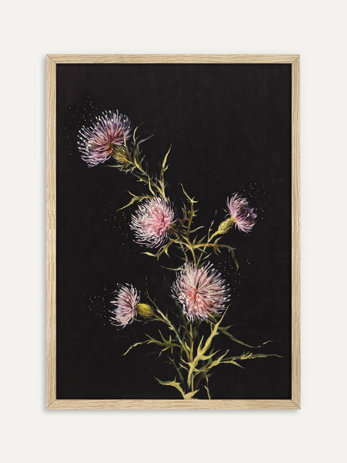 Kunstdruck, der fünf rosa und lila Distelblüten an stacheligen grünen Stielen vor tiefschwarzem Hintergrund zeigt, umgeben von feinen goldenen Punkten. Im Rahmen aus hellem Holz wird die Distelstudie zum ruhigen botanischen Blickfang. #Rahmen_Helles Holz
