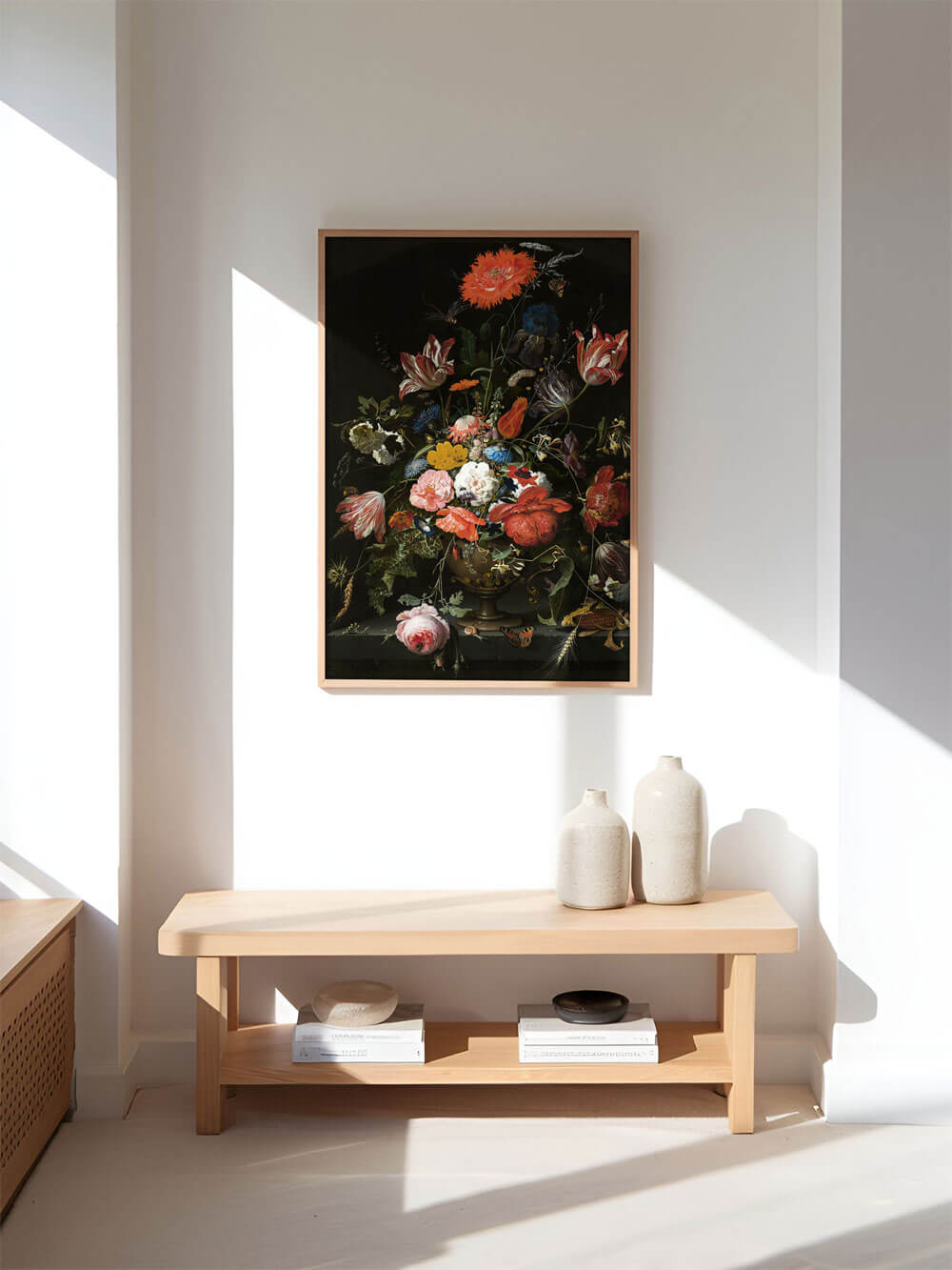 Kunstdruck eines opulenten barocken Blumenstilllebens, das in kräftigen Farben wie Rot, Orange und Blau auf schwarzem Hintergrund leuchtet. Der Druck ist in einem schlichten Holzrahmen und hängt in einem minimalistischen Flur über einer hellen Bank mit Keramikvasen. Sanftes Sonnenlicht durchflutet den Raum und betont das satte Farbspektrum der Blumen.