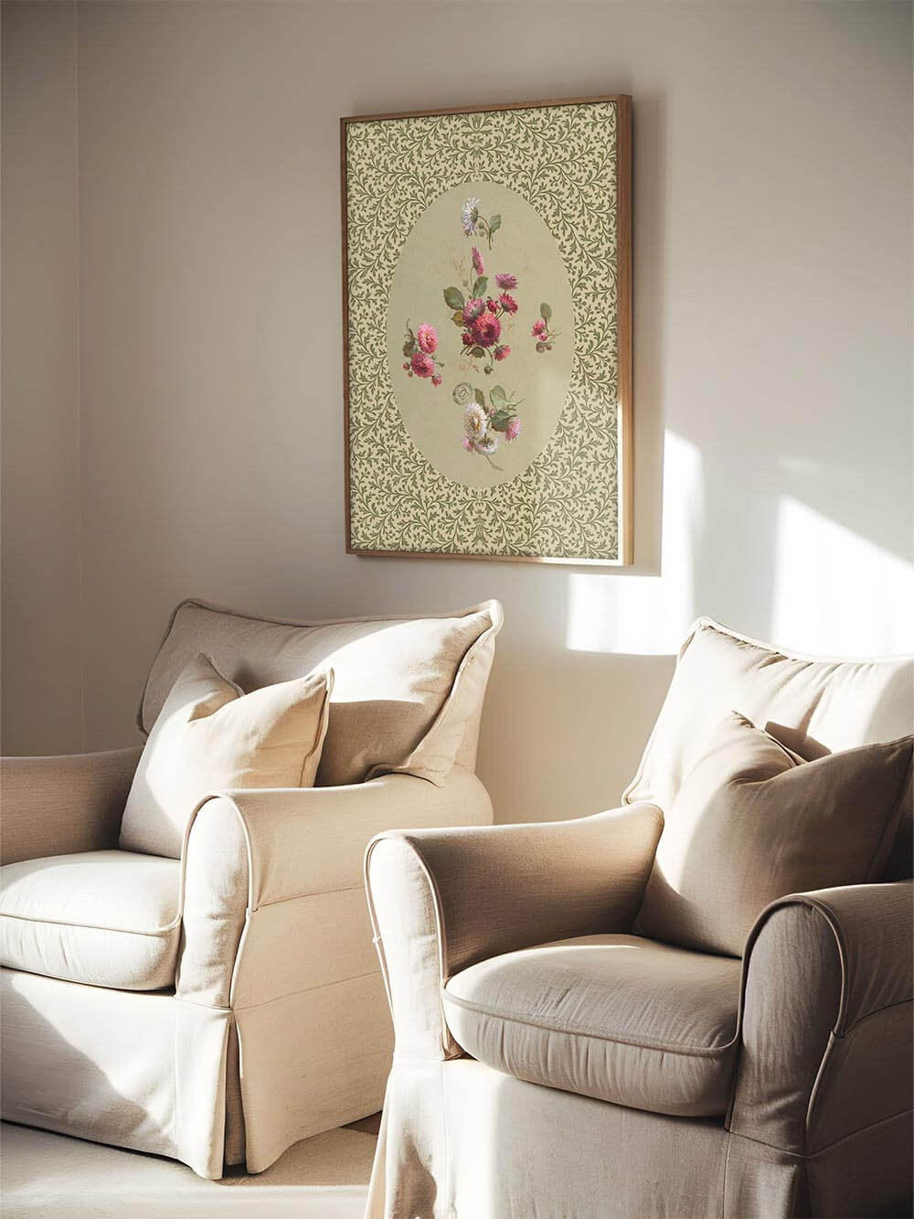 Der florale Kunstdruck hängt gerahmt in einem lichtdurchfluteten Wohnzimmer über zwei beigen Sesseln. Die sanften Farben unterstreichen den ruhigen Cottagecore-Stil.