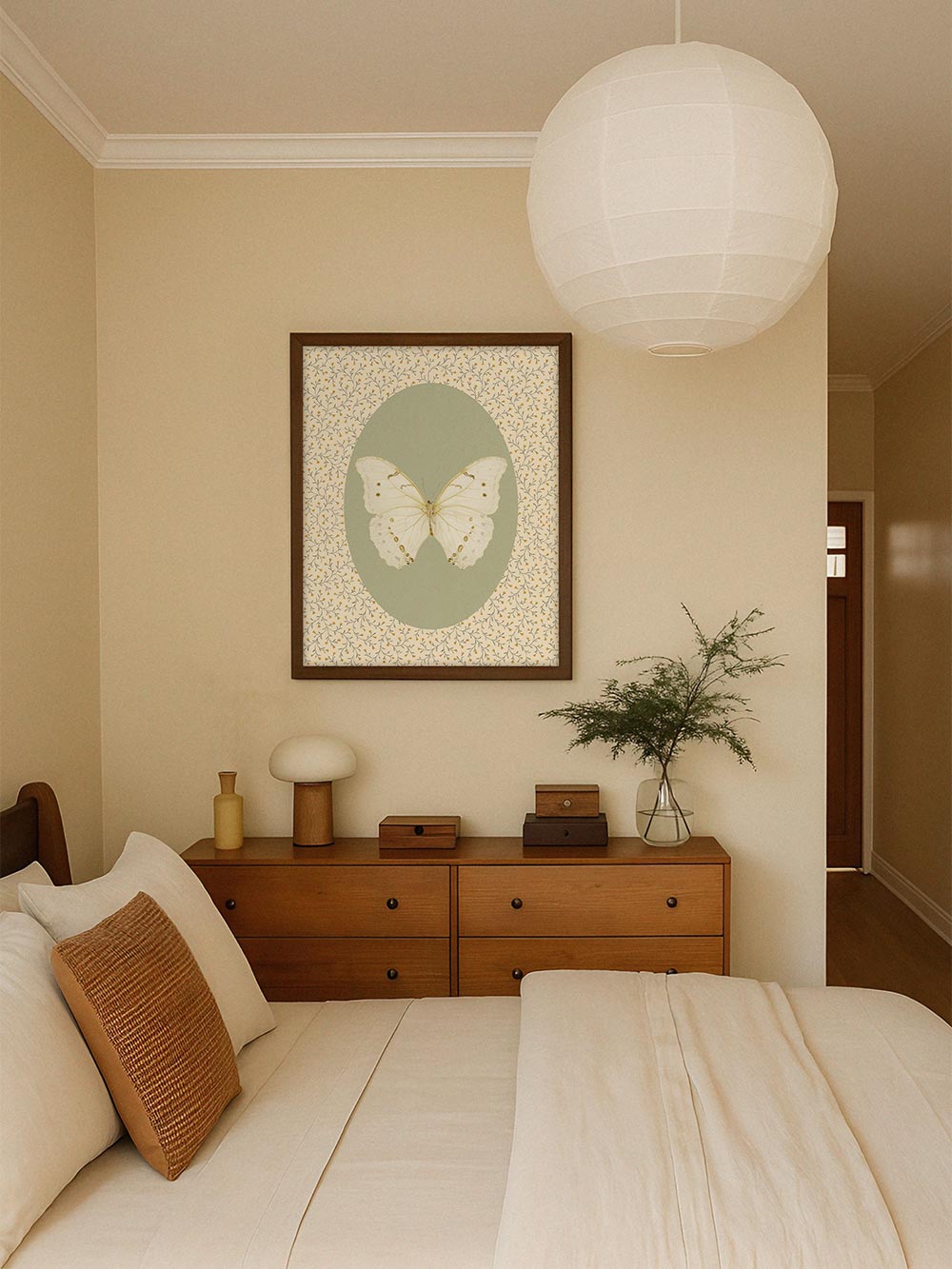 Der Vintage-Schmetterlingsdruck hängt über einer Holzkommode in einem hellen Schlafzimmer, das sanfte Farbspiel unterstreicht den ruhigen Landhausstil.