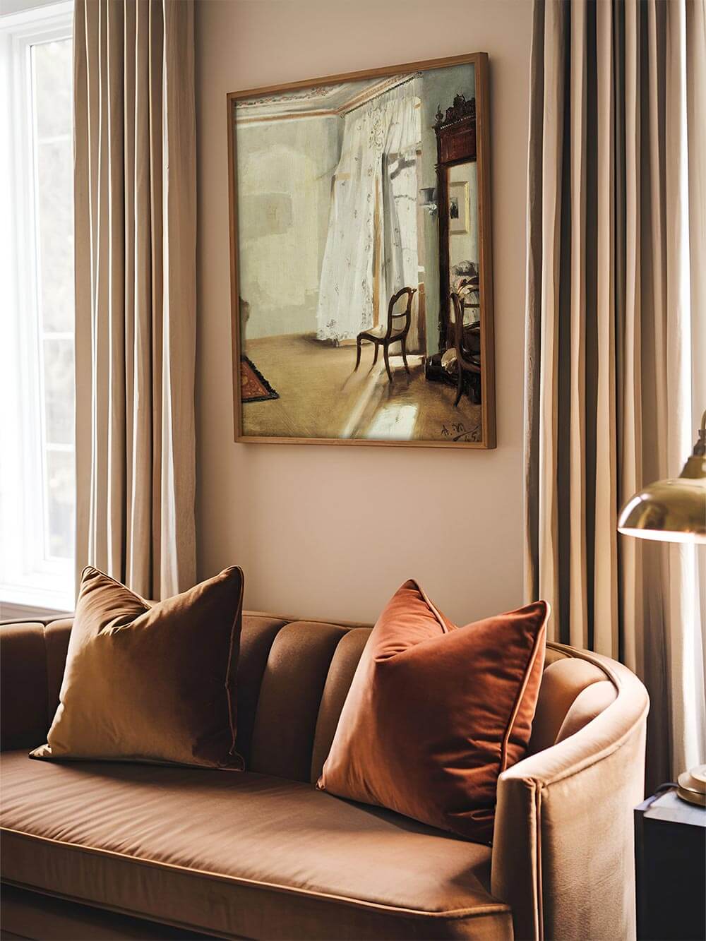 Stimmungsvolles Vintage-Interieur-Wandbild über einem stilvollen, samtigen Sofa in warmen Brauntönen. Die impressionistische Malerei fängt das einfallende Licht in einem eleganten Raum mit filigranen Möbeln und zarten Vorhängen ein.