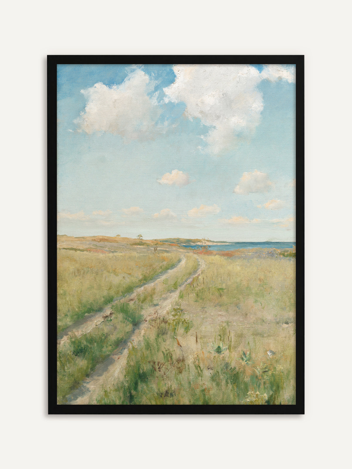 Gerahmtes Poster, das einen sandigen Feldweg zeigt, der sich durch eine grüne Sommerwiese zum blauen Meer zieht, darüber große weiße Wolken an einem hellen Himmel. Der schwarze Rahmen setzt das helle Blau des Vintage Motivs klar in Szene. #Rahmen_Schwarz