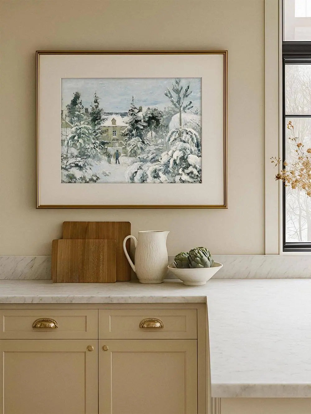 Winterlandschaft Kunstdruck in heller Küche gerahmt, die verschneite Szene mit Haus und Bäumen fügt sich harmonisch in das warme, natürliche Interieur ein.