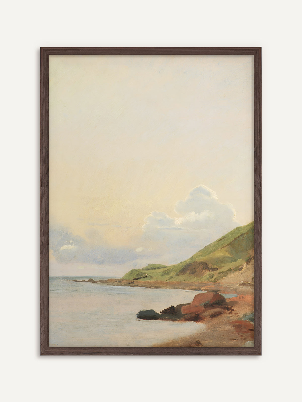 Poster, das eine stille Bucht mit hellem Wasser, rötlichen Felsen am Strand und einem grünen Hügel unter einem weiten, sanft gelben Himmel mit weißen Wolken zeigt. Der Rahmen aus dunklem Holz gibt den zarten Pastelltönen Halt und wirkt antik. #Rahmen_Dunkles Holz