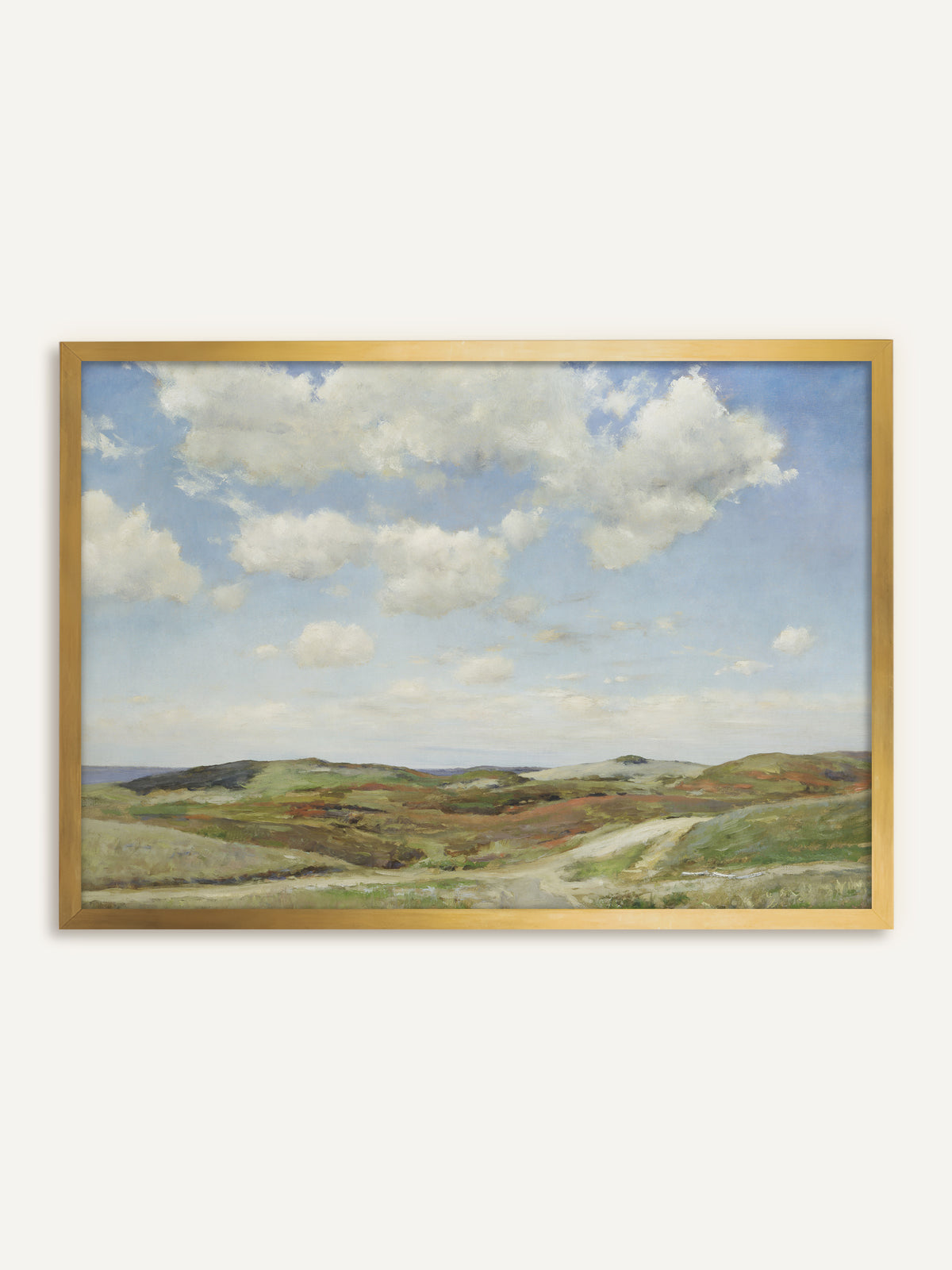 Wandbild, das eine Dünenlandschaft mit weißen Sommerwolken über sandigen Hügeln zeigt, bewachsen mit Heide in Grün und Rostrot, durch die ein heller Weg zum Meer führt. Im goldenen Rahmen wirkt die Vintage Landschaft wie ein antikes Ölgemälde. #Rahmen_Gold