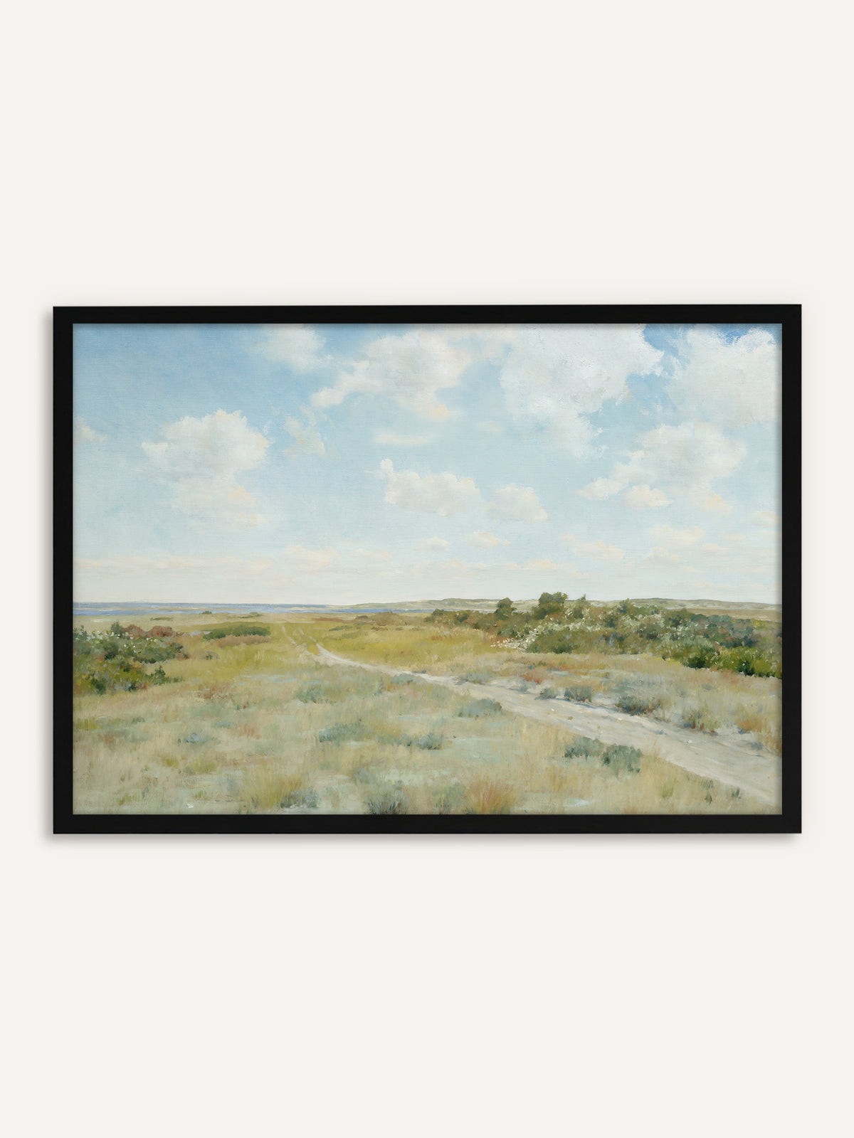 Gerahmtes Poster, das eine Heidelandschaft mit einem sandigen Weg durch salbeigrünes Gras und blühende Büsche zeigt, am Horizont blaues Wasser unter weißen Wolken. Mit schwarzem Rahmen wird die Vintage Landschaft klar und modern. #Rahmen_Schwarz
