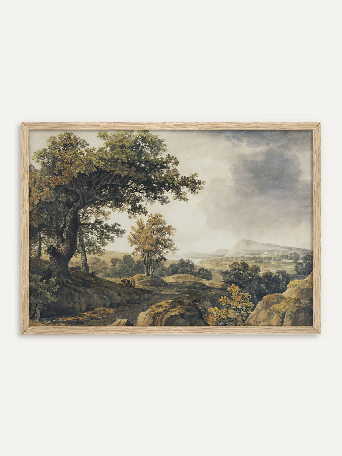 Kunstdruck, der eine weite Landschaft mit einer alten Eiche am Hang, einem Felsweg und Bäumen in Grün und Ocker unter grauen Regenwolken zeigt, in der Ferne ein Berg über einem See. Im Rahmen aus hellem Holz wirkt die Vintage-Landschaft ruhig und natürlich. #Rahmen_Helles Holz