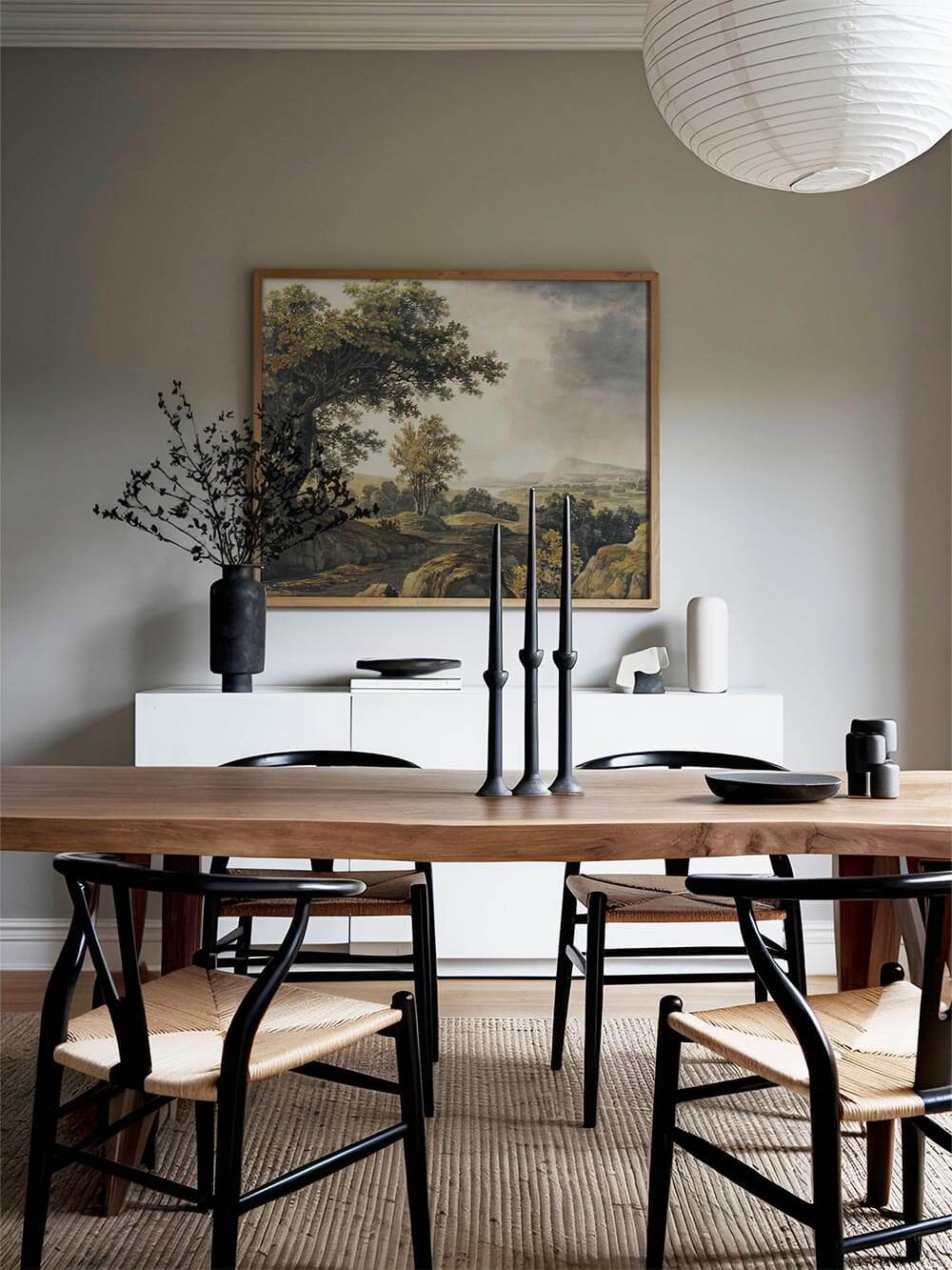 Im Esszimmer hängt der gerahmte Landschafts-Kunstdruck über einem modernen Holztisch. Das Vintage Wandbild fügt sich harmonisch in das reduzierte Interieur ein.