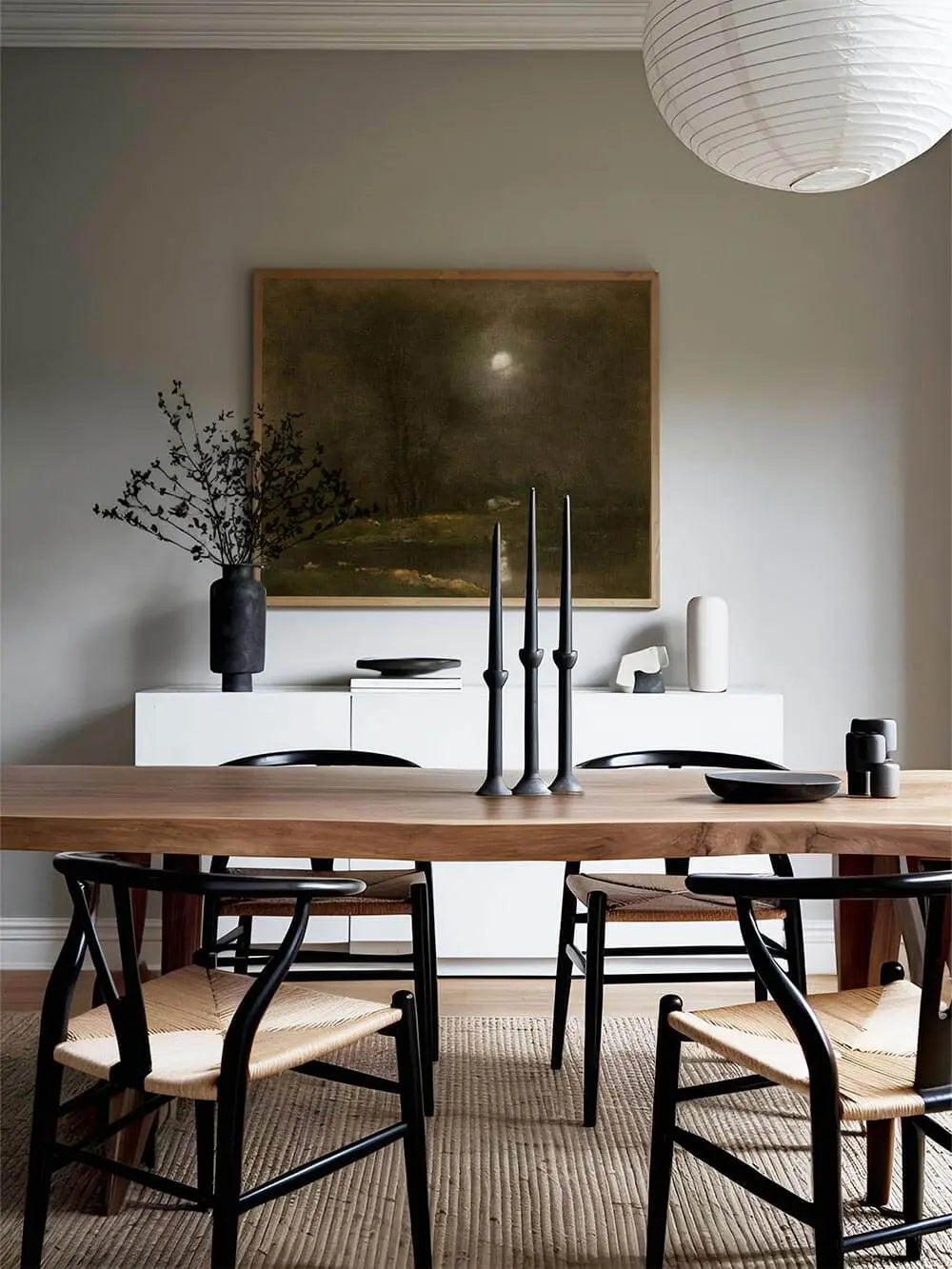 Gerahmter Kunstdruck einer nächtlichen Landschaft mit Mondlicht hängt über einer weißen Kommode im Esszimmer, das Vintage Wandbild wirkt elegant und beruhigend.