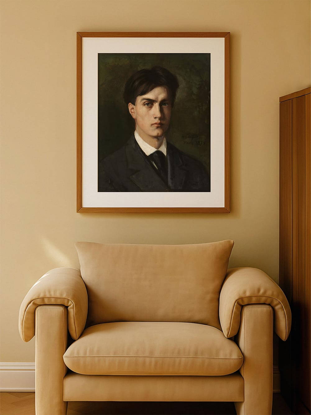 Eleganter Kunstdruck eines ernsten jungen Mannes im Anzug in einem Holzrahmen, stilvoll präsentiert über einem beigefarbenen Sessel – harmonisch in einem ruhigen Vintage-Interieur arrangiert.