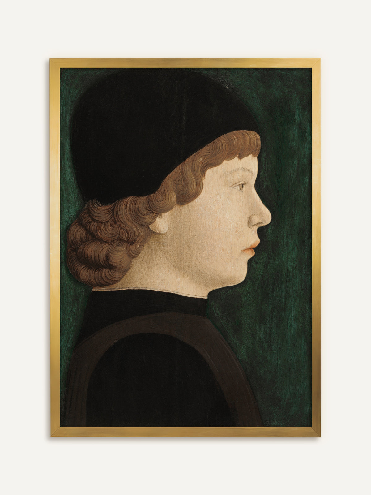 Wandbild, das einen Jungen im Profil zeigt, der unter einer schwarzen Kappe hellbraune, eingerollte Locken trägt, dazu ein dunkles Gewand vor tiefgrünem Hintergrund. Im goldenen Rahmen wirkt das Bild wie ein antikes Tafelbild. #Rahmen_Gold