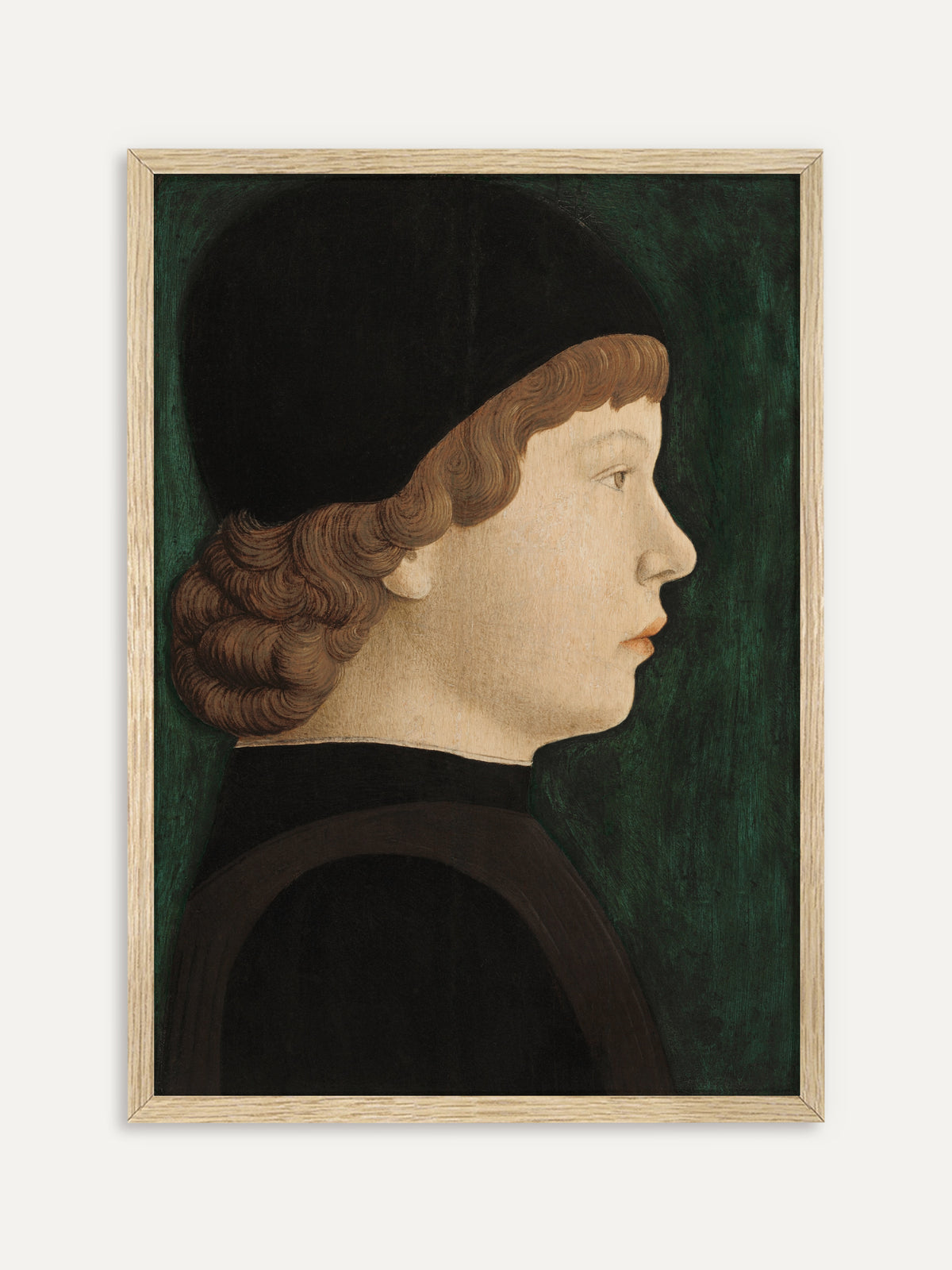 Kunstdruck, der einen Jungen im Profil zeigt, der unter einer schwarzen Kappe hellbraune, eingerollte Locken trägt, dazu ein dunkles Gewand vor tiefgrünem Hintergrund. Im Rahmen aus hellem Holz wirkt das Renaissance-Porträt ruhig und hell. #Rahmen_Helles Holz