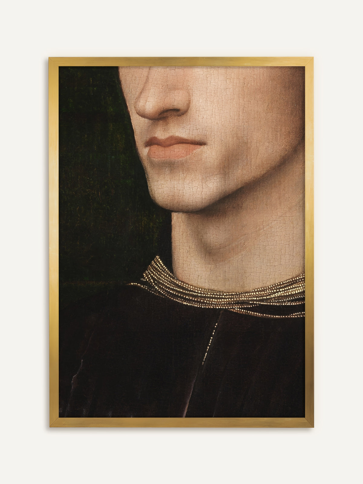 Wandbild, das als Ausschnitt Nase, Mund und Kinn eines jungen Mannes zeigt, mit heller Haut voller feiner Risse im alten Firnis, dazu ein dunkles Samtgewand mit goldbesticktem Kragen vor dunkelgrünem Grund. Im goldenen Rahmen greift das Bild die Goldstickerei auf und wirkt wie ein antikes Gemälde. #Rahmen_Gold