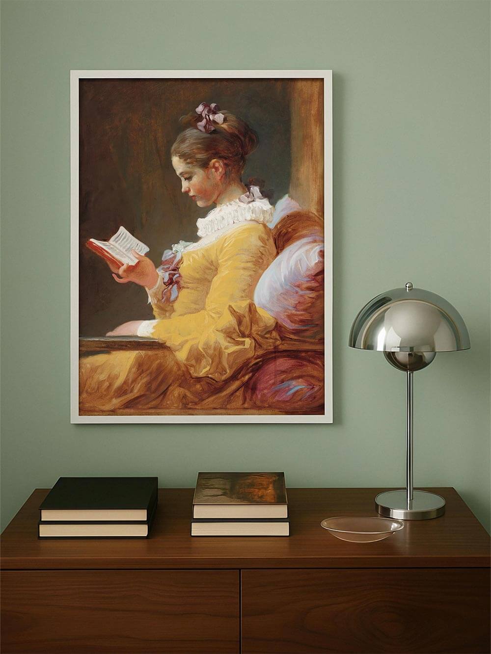 Porträt einer lesenden Frau im gelben Kleid, elegant gerahmt und platziert über einer modernen Kommode – sanfte Rokoko-Farbpalette trifft auf minimalistisches Interior.