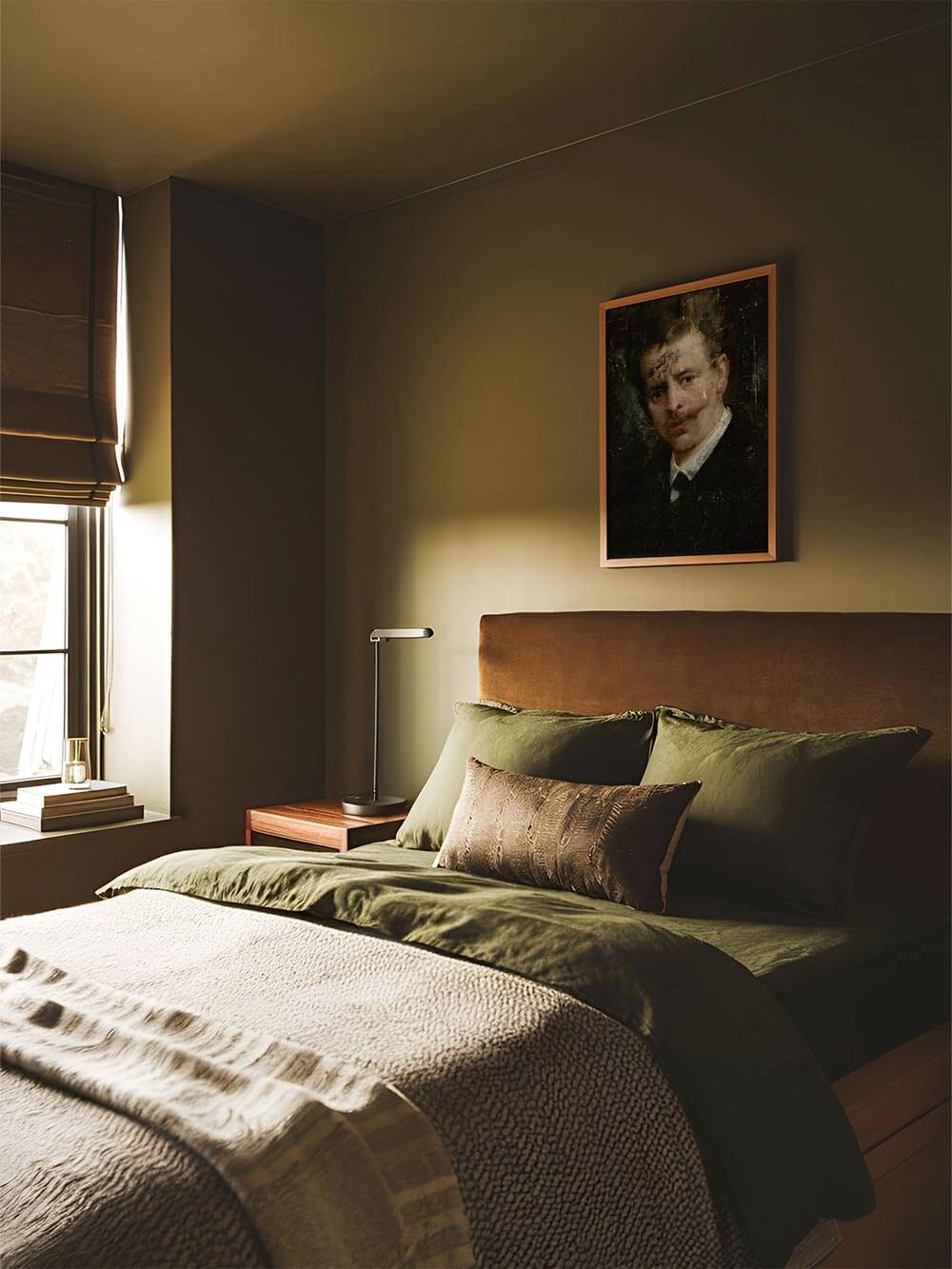 Der Vintage Kunstdruck mit Männerporträt hängt über einem Bett mit grüner Bettwäsche. Das Wandbild bringt ruhige Eleganz und einen Hauch von Geschichte ins Schlafzimmer.
