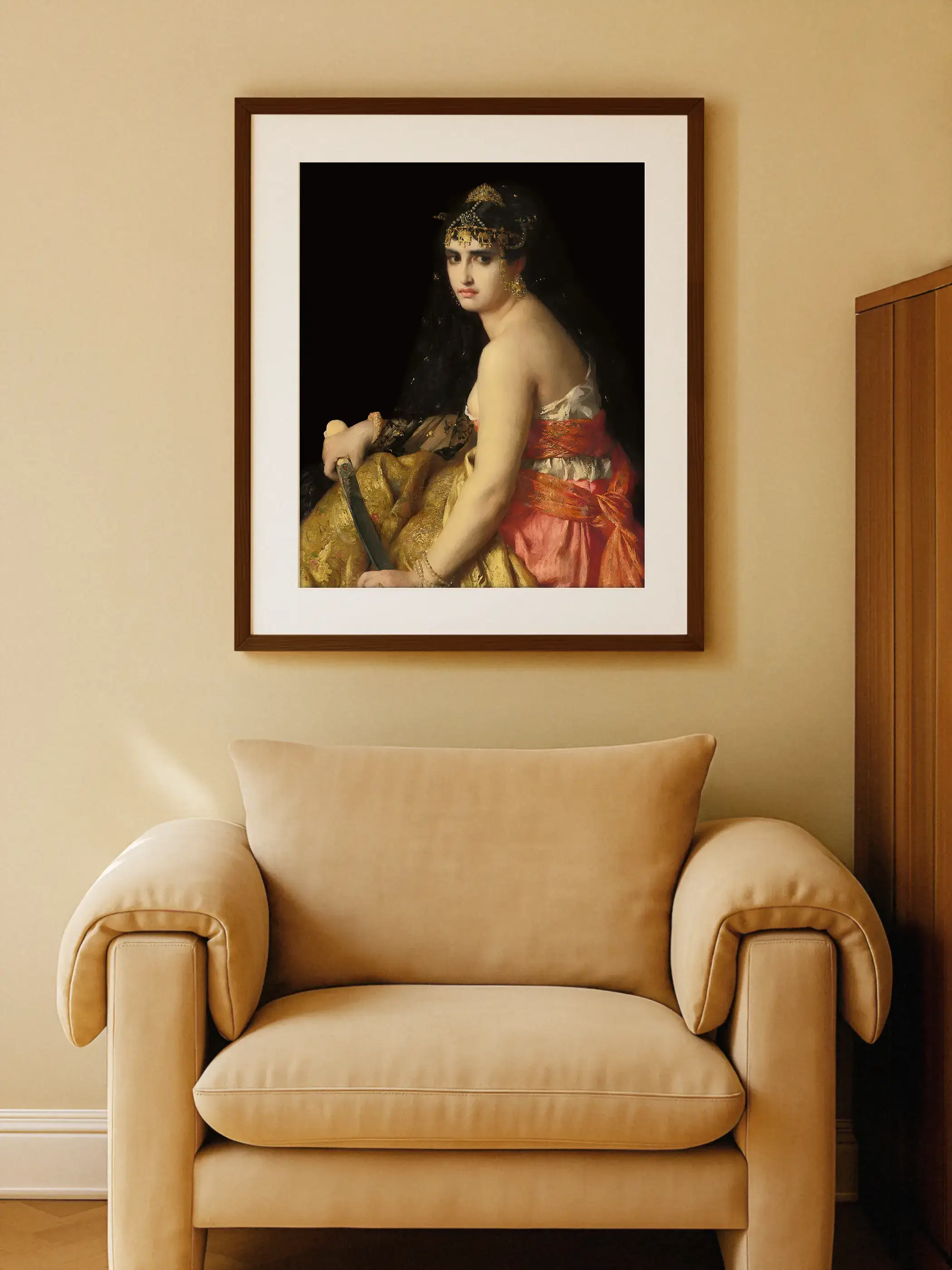 Gerahmtes Dark Academia Porträt von Judith hängt an beigefarbener Wand über einem cremefarbenen Sessel mit Kissen. Das dramatische Wandbild setzt einen eleganten Kontrast im warmen Wohnzimmer.