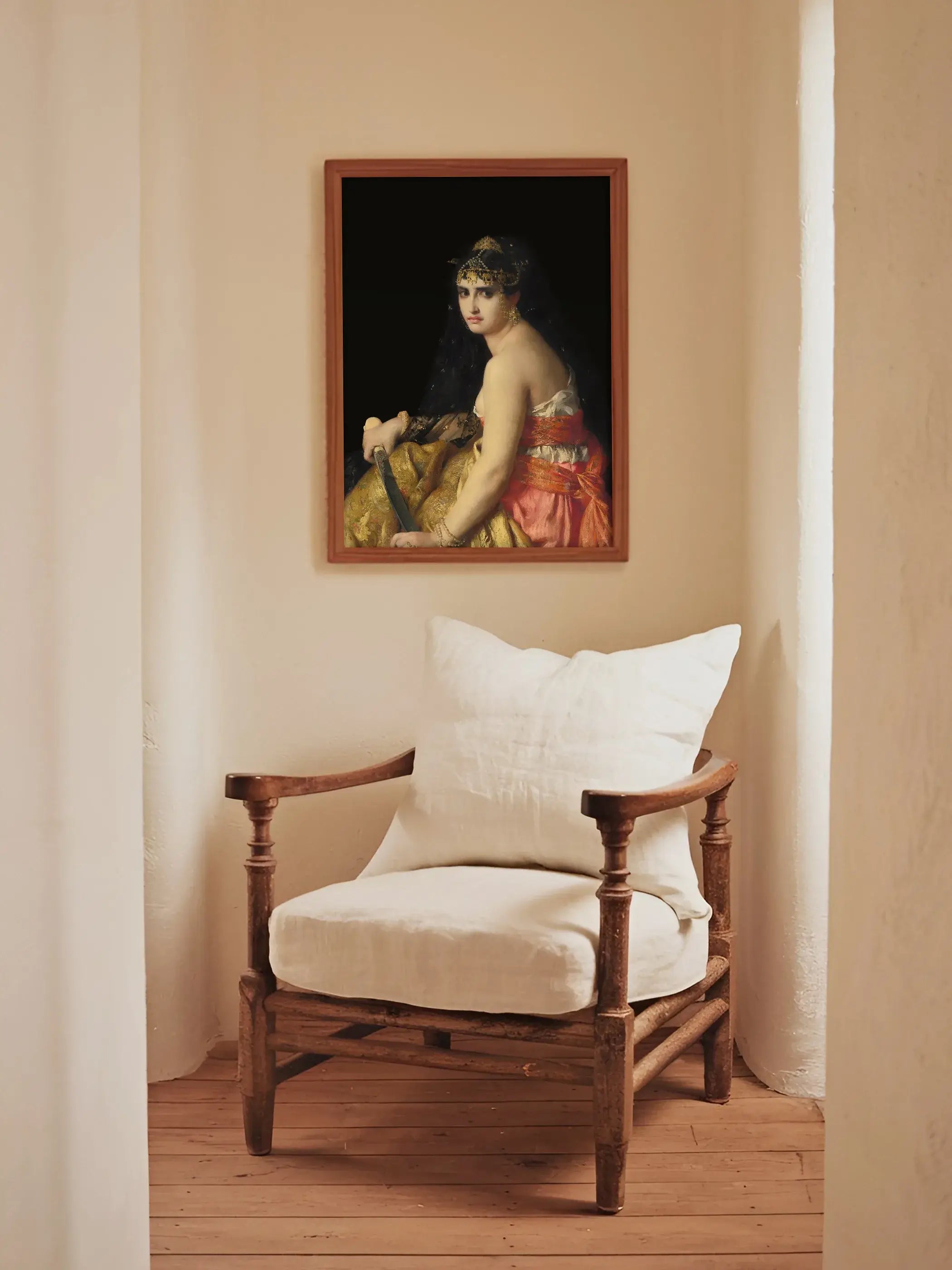 Dark Academia Kunstdruck mit Judith hängt gerahmt über einem rustikalen Holzsessel mit weißem Kissen in einem hellen, warmen Eingangsbereich. Das kontrastreiche Wandbild wirkt edel und geheimnisvoll.