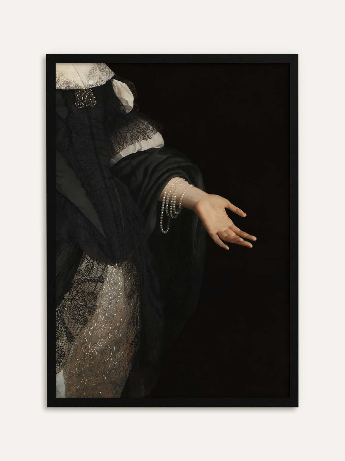 Gerahmtes Poster, das eine ausgestreckte Hand mit mehreren Perlenketten am Handgelenk zeigt, die vor tiefschwarzem Hintergrund aus einem schwarzen Seidenkleid mit Spitze ragt. Mit schwarzem Rahmen wird das moody Wandbild noch dunkler und geschlossener. #Rahmen_Schwarz