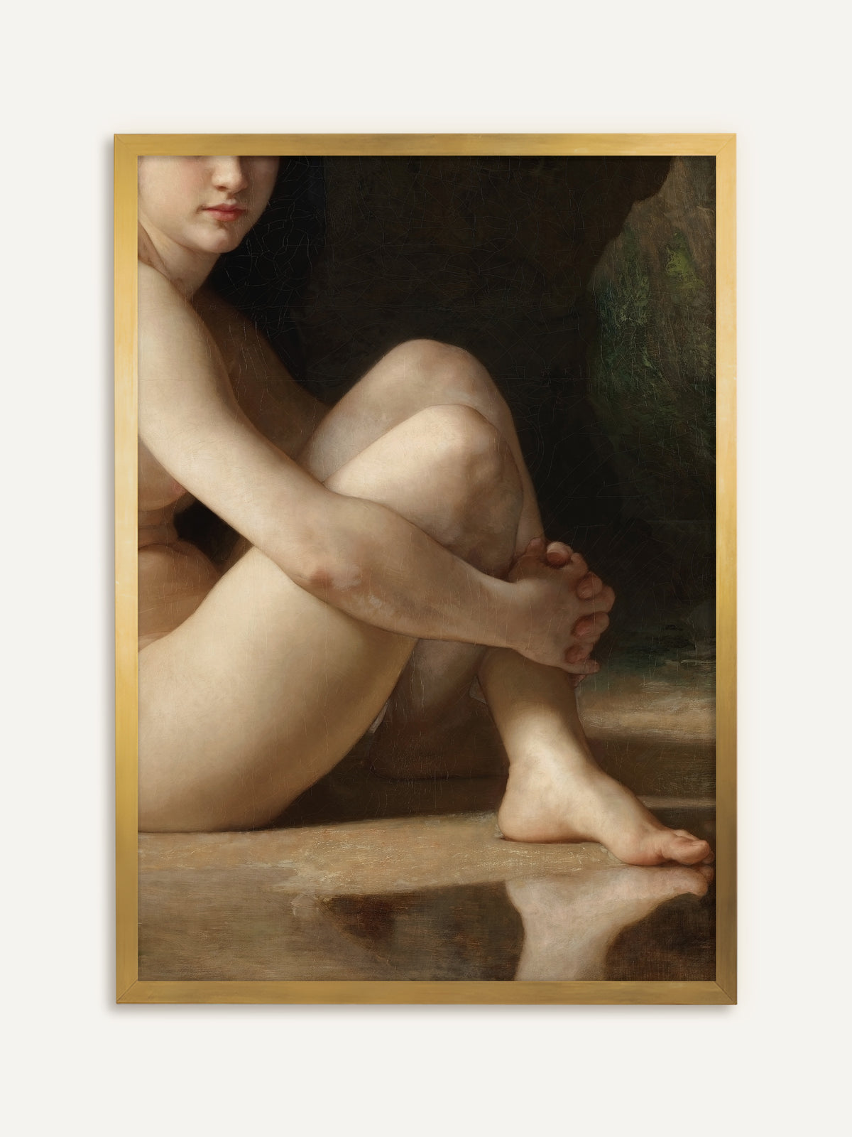 Eine nackte Frau sitzt mit angezogenen Knien am Wasser und umfasst ihr Schienbein, ihr Fuß spiegelt sich in der glatten Wasserfläche, dahinter dunkler Fels. Im goldenen Rahmen wirkt der Kunstdruck wie ein antikes Gemälde aus einem Salon. #Rahmen_Gold