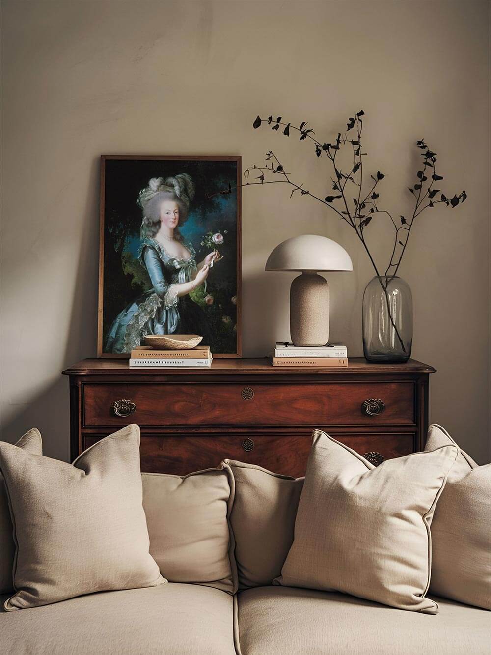 Gerahmter Rokoko-Kunstdruck von Marie Antoinette in eleganter Umgebung, die harmonisch mit beigen Kissen, einem Holzsideboard und minimalistischer Dekoration kombiniert ist.