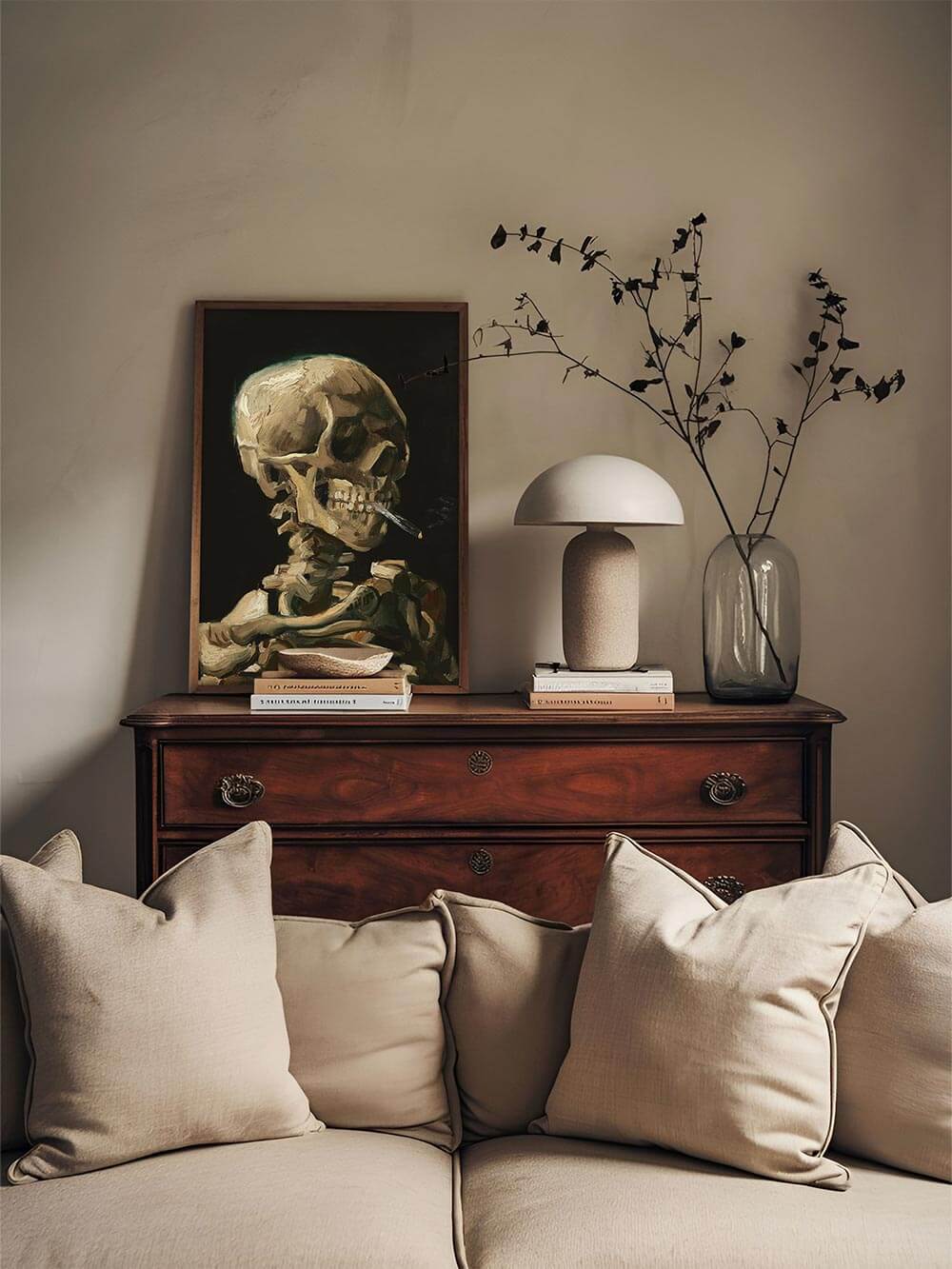 Skelett-Kunstdruck in Holzrahmen auf Kommode neben Keramikvase und Büchern. Die erdigen Töne und das Lichtspiel bringen eine ruhige, intellektuelle Stimmung in den Raum.