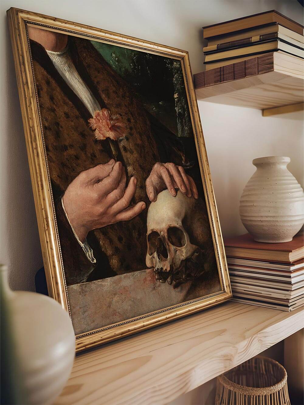 Gerahmter Vanitas-Kunstdruck mit Schädelmotiv auf Holzregal zwischen Büchern und Vasen. Die Komposition strahlt nostalgische Eleganz aus – ideal für Dark-Academia- oder Gothic-Interior-Design.