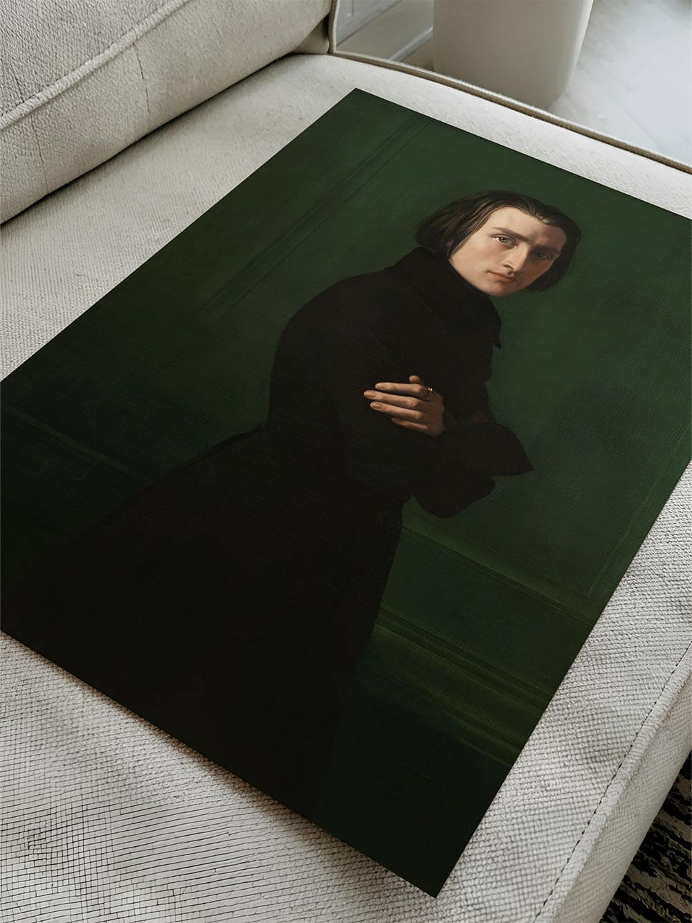 Der ungerahmte Franz Liszt Kunstdruck liegt auf einem hellen Sofa. Die intensive Farbwirkung des grünen Hintergrunds kommt im Kontrast zur Umgebung besonders gut zur Geltung.