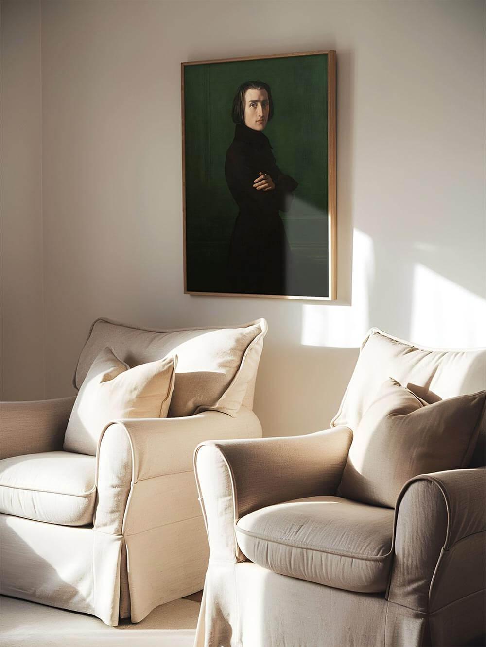 Der gerahmte Franz Liszt Kunstdruck hängt in einem hellen Wohnzimmer über zwei beigen Sesseln. Das tiefgründige Porträt verleiht dem Raum eine ruhige, intellektuelle Atmosphäre.