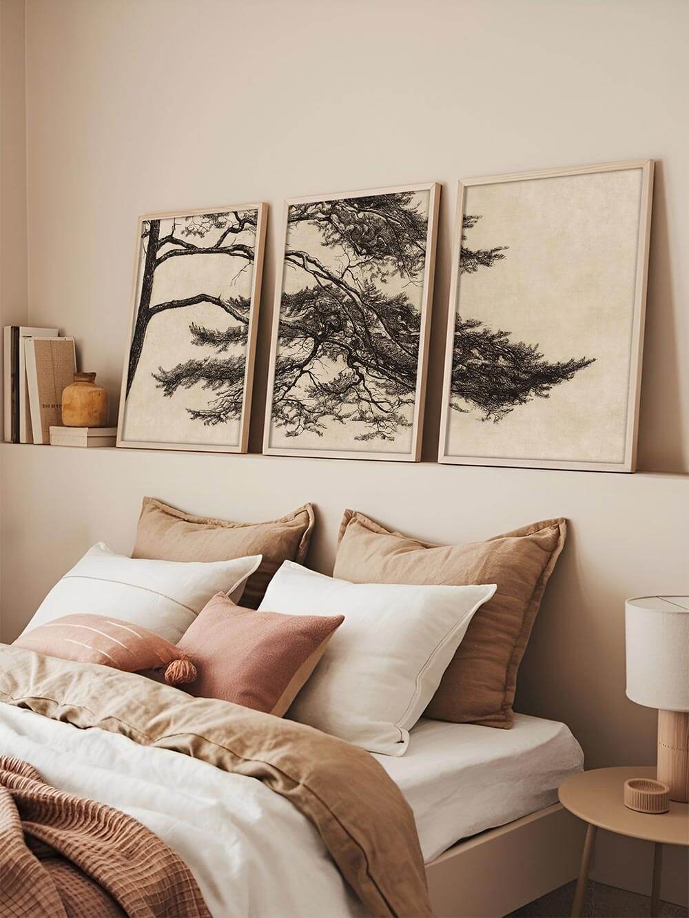 Dreiteiliges Wandbild mit Kiefernästen über einem Bett in warmen Naturtönen. Der Wabi-Sabi-Kunstdruck strahlt Ruhe und Balance aus, ideal für minimalistische Schlafzimmergestaltung mit harmonischer Atmosphäre.
