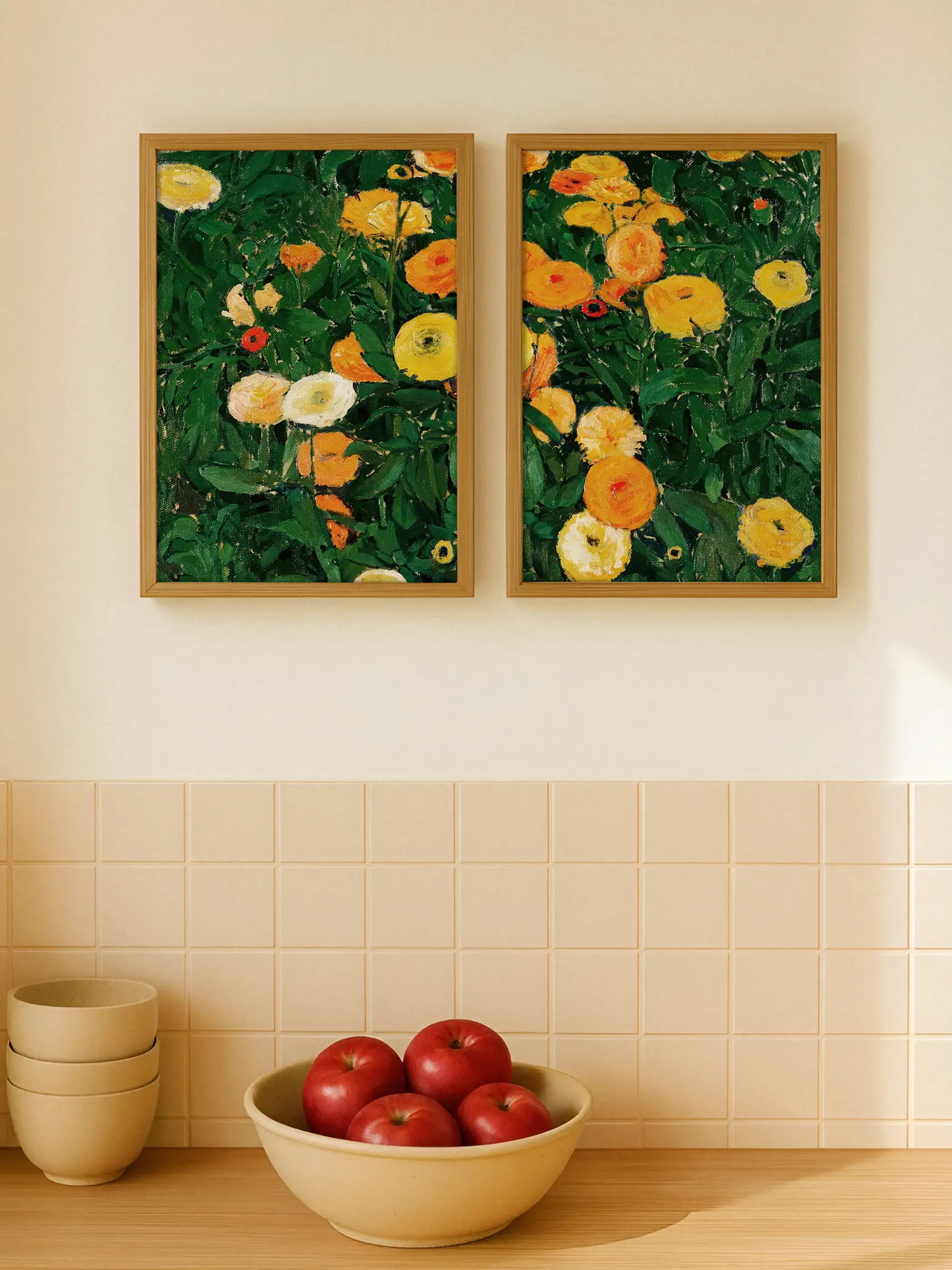 Das zweiteilige Blumenposter-Set mit Ringelblumen hängt über einer hellen Küchenzeile mit Schale roter Äpfel. Die warmen Gelb- und Orangetöne der Kunstdrucke bringen freundliche Farbe und natürliche Lebendigkeit in die Küche.
