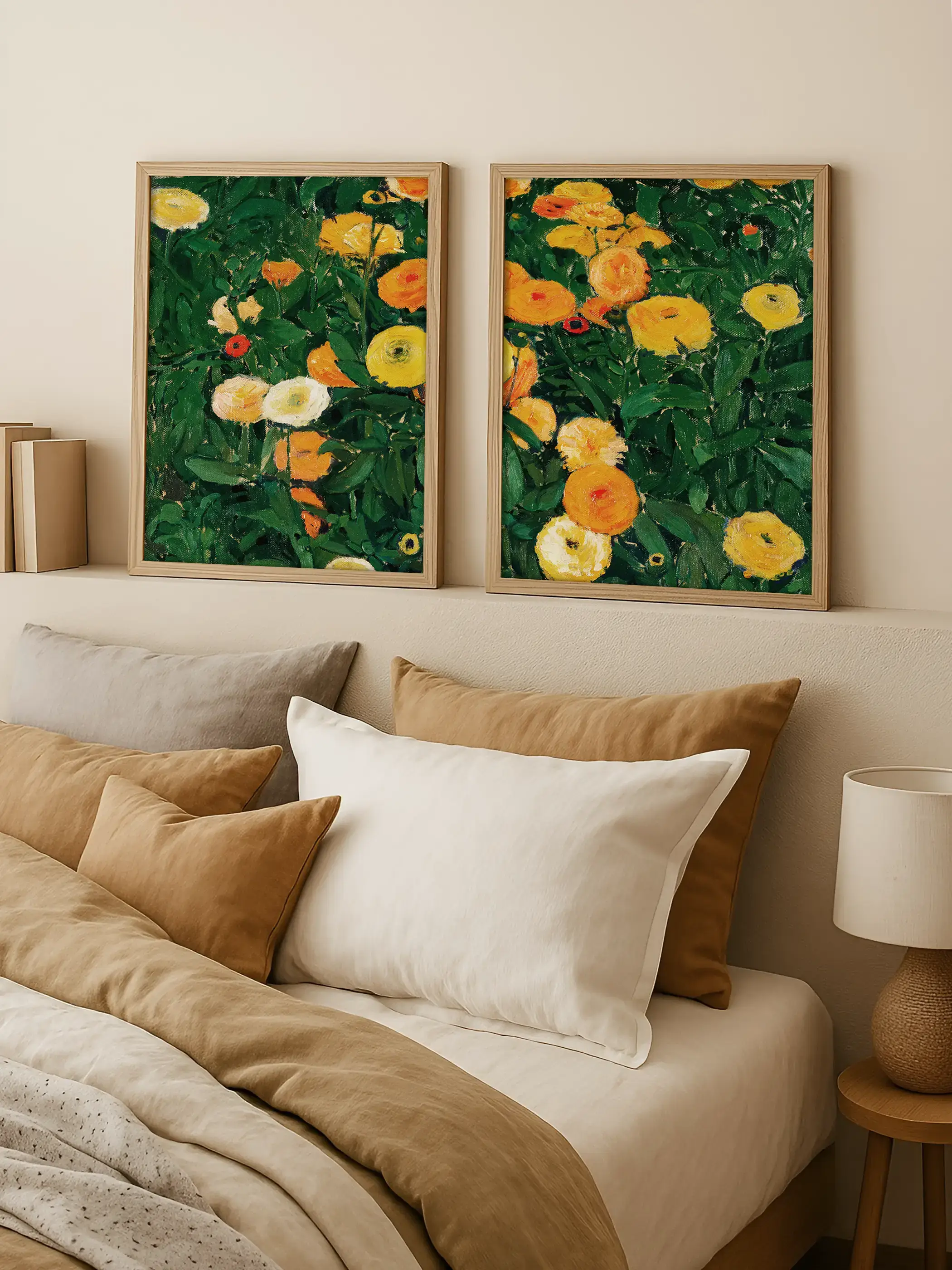 Zwei gerahmte Kunstdrucke mit leuchtenden Ringelblumen in Gelb, Orange und Creme hängen über einem Bett mit beigen Kissen. Das florale Wandbild bringt warme Farbe in ein ruhiges Schlafzimmer im natürlichen, modernen Stil.