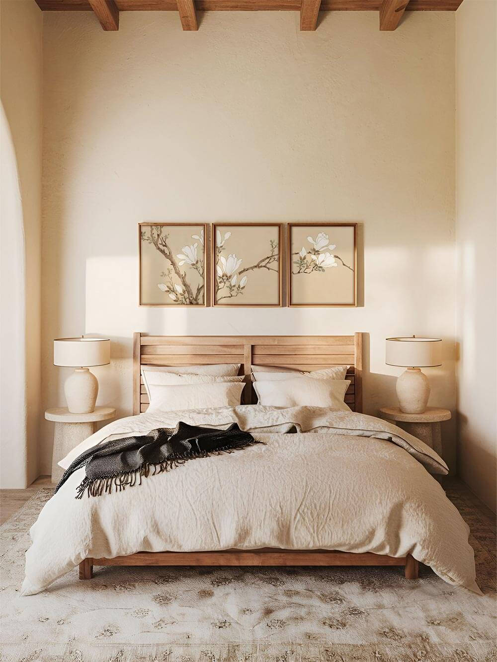 Bilderset über einem Bett im Schlafzimmer: Drei gerahmte Kunstdrucke mit stilisierten Magnolienzweigen in einem neutral gehaltenen Schlafzimmer, das eine beruhigende Japandi-Atmosphäre ausstrahlt.