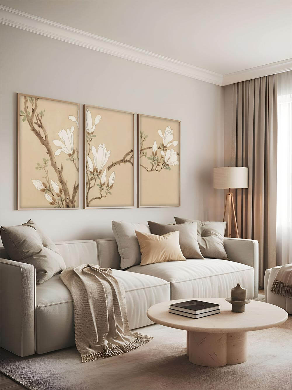 Drei großformatige Japandi-Kunstdrucke mit Magnolienblüten an einer modernen, neutral gestalteten Wohnzimmerwand über einem Sofa. Die sanfte Farbpalette harmoniert mit minimalistischer Einrichtung.