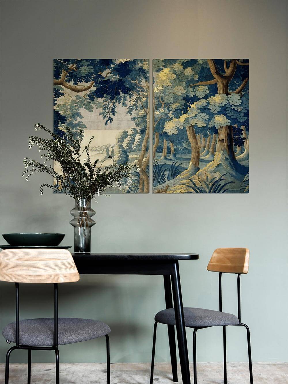 Gerahmtes Landschafts-Kunstdruck-Set in Blautönen hängt an einer grünlich-grauen Wand über einem modernen Esstisch mit schwarzen Akzenten.