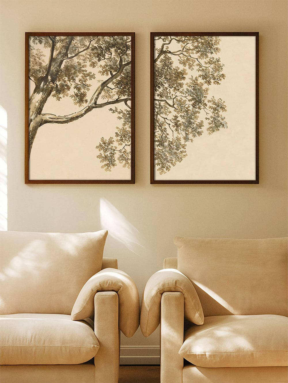 Zwei aufeinander abgestimmte Kunstdrucke mit Baumzweigen hängen über zwei Sesseln in einem warmen, neutralen Wohnzimmer. Das Set schafft eine ruhige Atmosphäre und eignet sich als stilvolles Wandbild für moderne oder klassische Einrichtung.