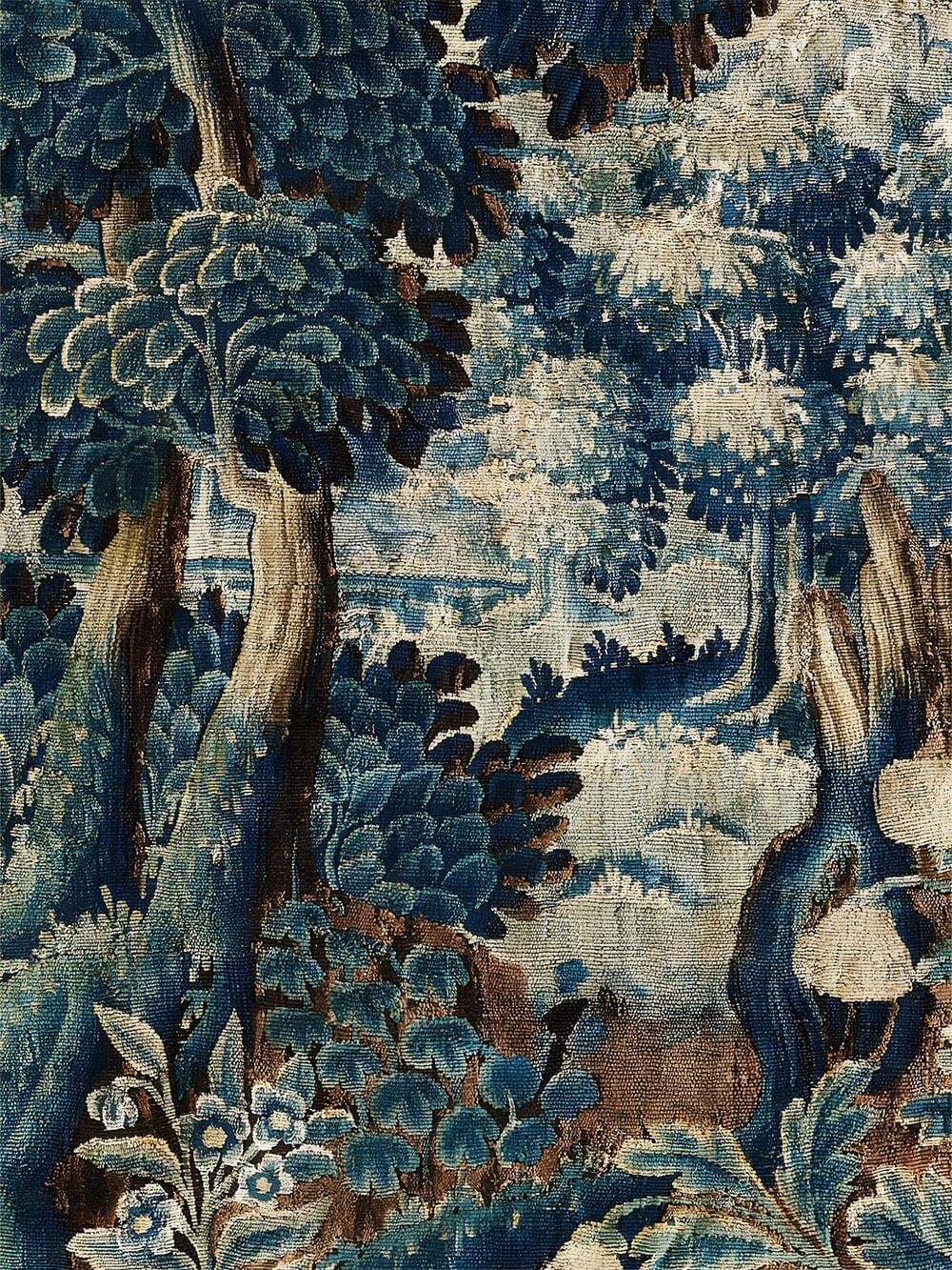 Nahaufnahme der gewebten Textilstruktur mit fein ausgearbeiteten Bäumen und Blattwerk in Blau, Grün und Beige. Die sichtbare Stoffanmutung unterstreicht den historischen Charakter des Verdure-Motivs als hochwertiger Kunstdruck.