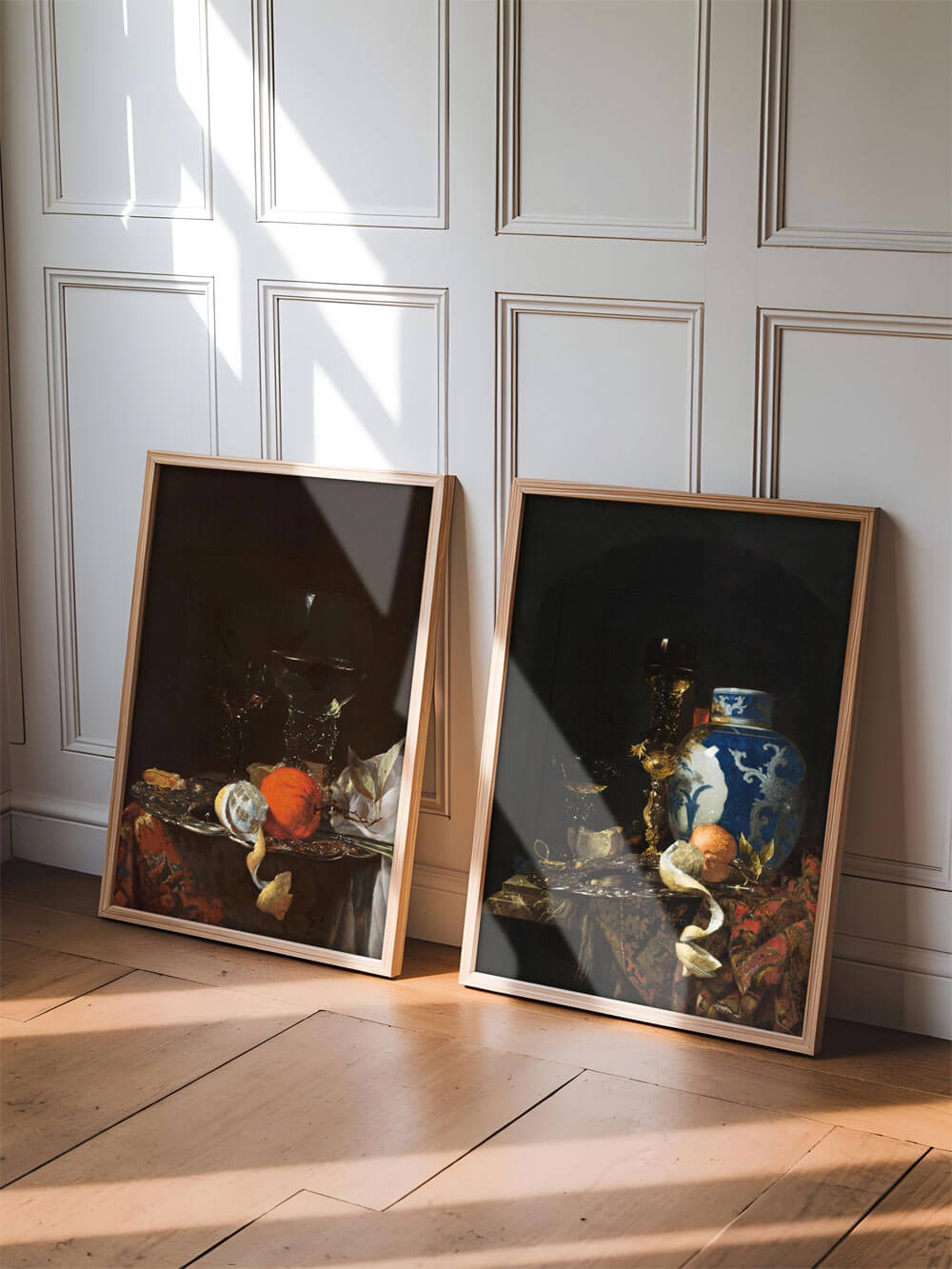 Zwei gerahmte barocke Stillleben-Kunstdrucke, auf den Holzboden gelehnt, mit natürlichem Lichteinfall durch ein Fenster.