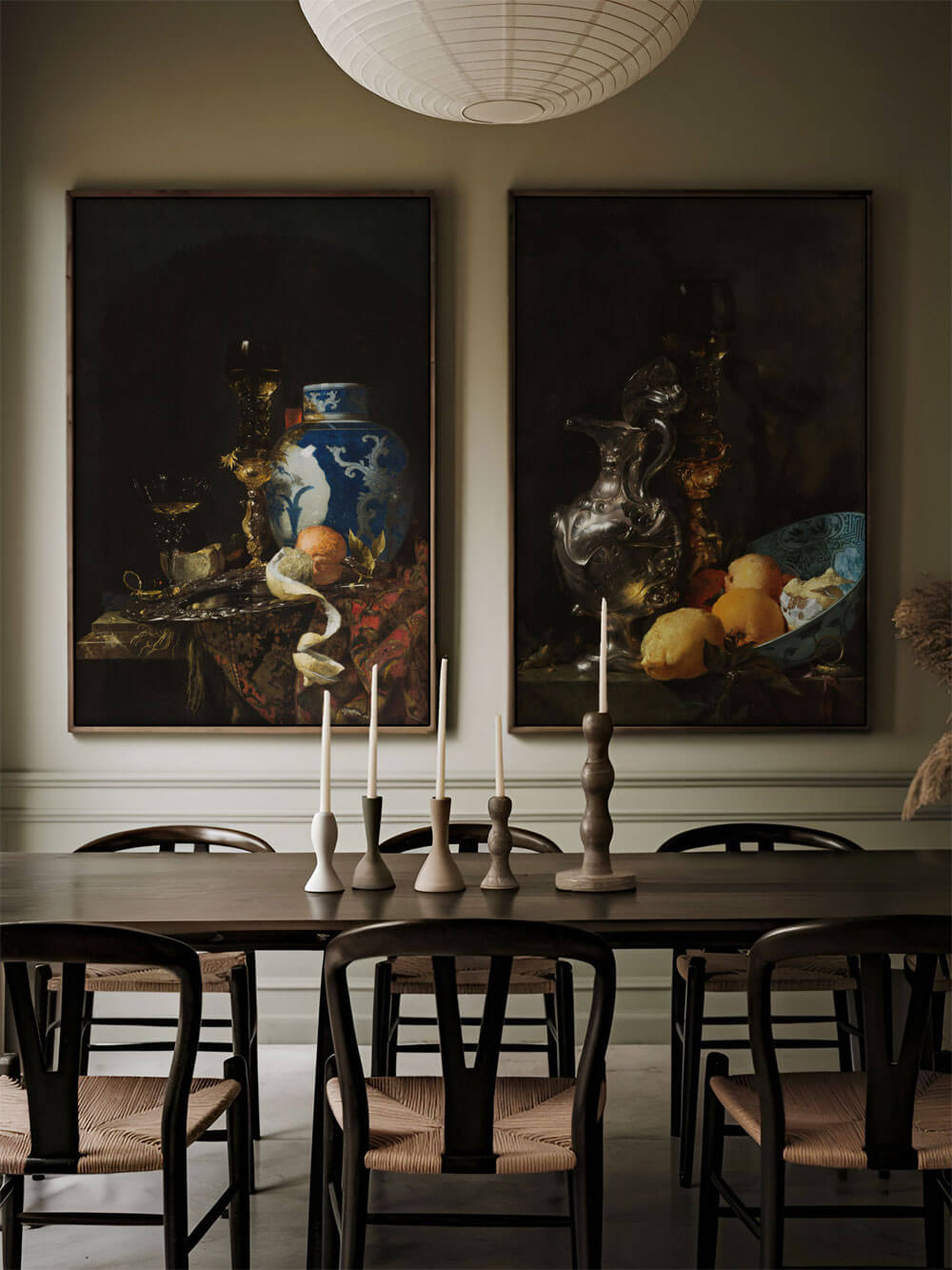 Zwei barocke Stillleben Kunstdruck mit blau-weißem Porzellan, Zitronen und Weinbechern, eingerahmt in einem moody Esszimmer mit Kerzenleuchtern.